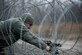 Staff Sgt. Adam Ross performs maintenance on concertina wire Dec. 12, 2013, at Transit Center at Manas, Kyrgyzstan. Concertina wire has razor-sharp edges, placed in coils as a barrier to deter anyone trying to breach a perimeter. Ross is a 376th Expeditionary Security Forces Squadron patrolman. (U.S. Air Force photo/Senior Airman George Goslin)