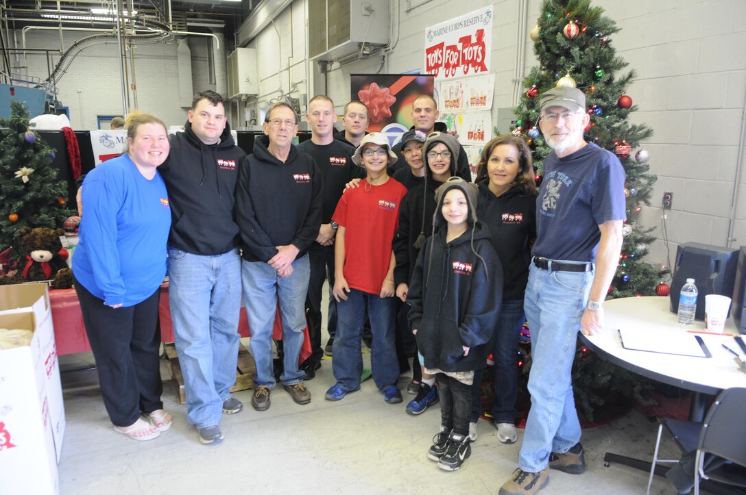 The Marines who staff Quantico’s Toys for Tots drive pose with some of the program’s regular volunteers at the Freelance-Star newspaper’s warehouse Dec. 20, the day before the toy drive ended. From left are Amanda McClure of Fredericksburg, Staff Sgt. Matthew Dennis, Al Michaels of Fredericksburg, Sgt. Shawn Palmer, Sgt. Jeremy Olson, 13-year-old Sam of Fredericksburg, Madelene Huff of Fredericksburg, Sgt. Justin Minnick, 11-year-old Lily of Fredericksburg, 8-year-old Abby of Fredericksburg, Norma Gonzalez of Stafford and Rick Schmirl of Fredericksburg.