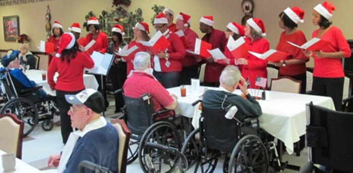 Huntsville Center employees visited residents of the Floyd E. "Tut" Fann Alabama State Veterans Home, Huntsville, Ala. Dec. 20 following the Holiday Town Hall gathering at the University of Alabama-Huntsville Student Center. Huntsville Center employees delivered more than 150 gift bags, put together with donations by the Center's work force, to the residents. Members of the Huntsville Center work force came together to form a Holiday Choir to sing at the town hall and outreach events.
