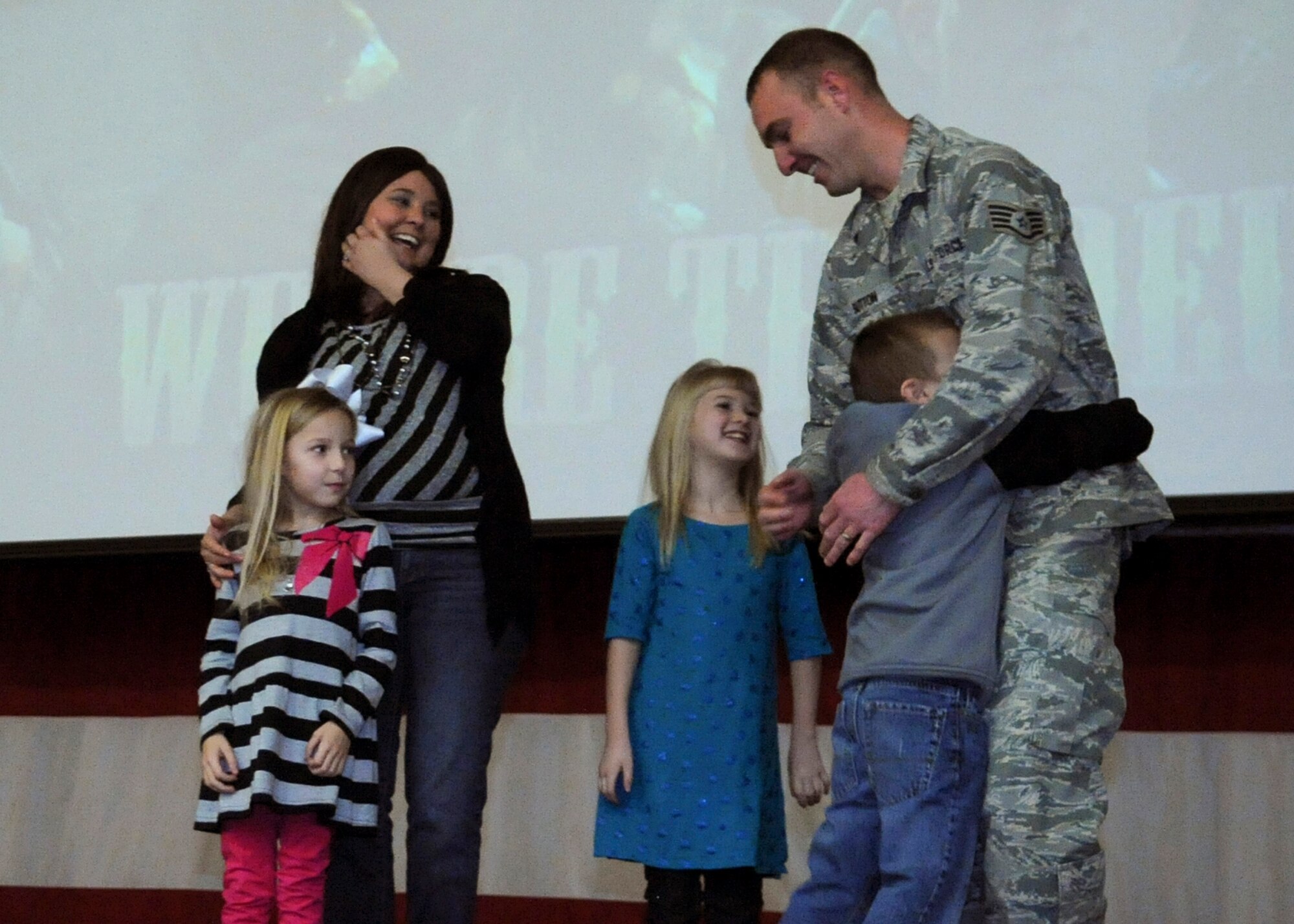 Staff Sgt. Curtis Sutton, 2nd Logistics Readiness Squadron vehicle operations control center assistance NCO in charge, hugs his son shortly after being promoted to technical sergeant under the Stripes for Exceptional Performers program at Barksdale Air Force Base, La., Jan. 3, 2014. Sutton and his family were surprised with a STEP-promotion during a 2nd Bomb Wing all-call. (U.S. Air Force photo/Senior Airman Kristin High)