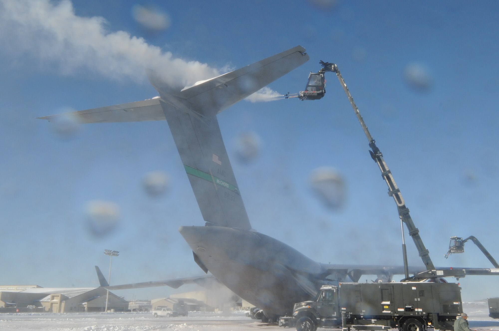 Members from the 736th Aircraft Maintenance Squadron spray deicing fluid onto the tail of a C-17A Globemaster III, based at Joint Base Lewis-McChord, Wash., Jan. 3, 2014, at Dover Air Force Base, Del. The year’s first major snowstorm hit the East Coast the night before, dropping 4 inches of snow onto Dover’s flight line.  The photographer and camera were hit by some of this fluid as it was blown off of the plane by the strong winds. (U.S. Air Force photo/Airman 1st Class Zachary Cacicia) 