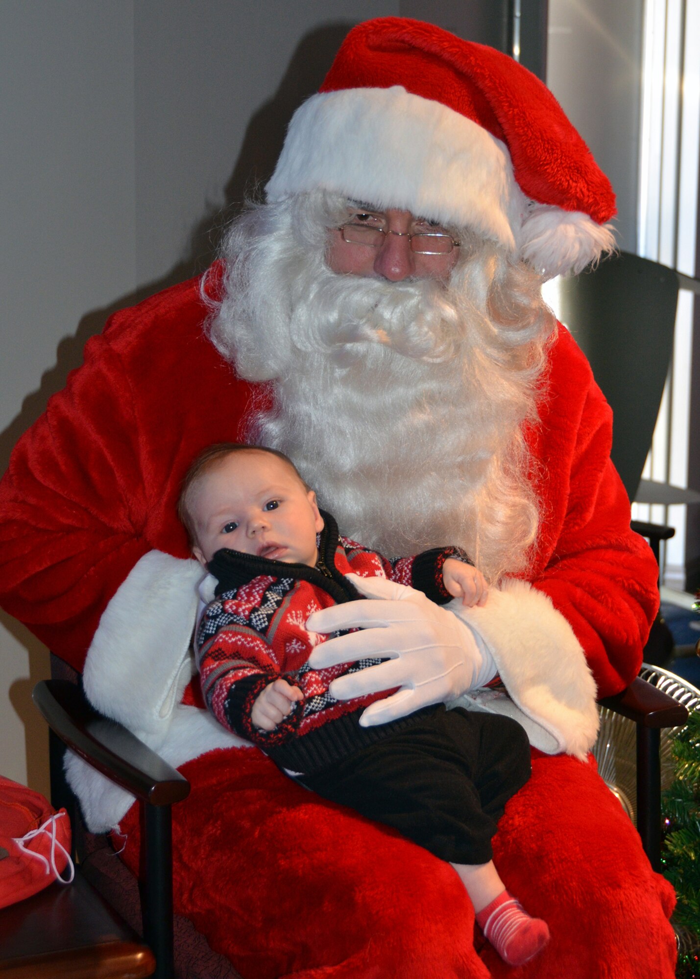 WRIGHT-PATTERSON AIR FORCE BASE, Ohio - Santa, played by Master Sgt. Jeff Vaughn, 89th Airlift Squadron loadmaster, holds 2-month old Nolan Leighty, son of Senior Airman Aaron Leighty, 445th Aeromedical Staging Squadron surgical technician, at the C-17 Fly-In event Dec. 7, 2013. The annual Santa-hosted event entertains young children related to members of the 445th Airlift Wing. (U.S. Air Force photo/Master Sgt. Charlie Miller)


