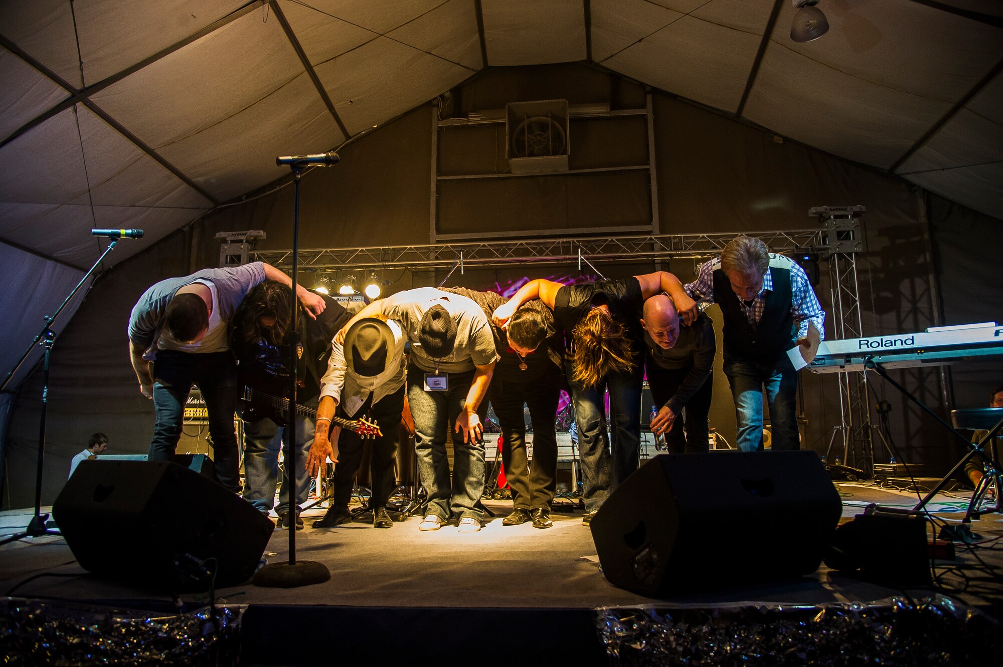 TOTO and Friends bow after finishing a concert at Transit Center at Manas, Kyrgyzstan, Dec. 31, 2013. Bobby Kimball, Alex Ligertwood and Bill Champlin performed for members of TCM to celebrate the New Year. More than 1200 Service members and civilian counterparts attended the event. (U.S. Air Force photo/Senior Airman George Goslin)