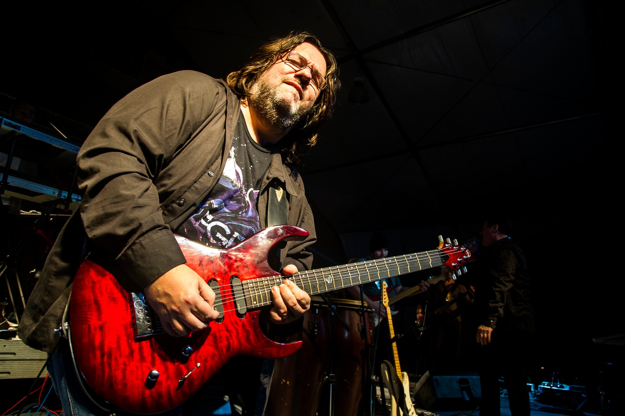 Tommy Denander, guitarist, plays a solo during a performance at Transit Center at Manas, Kyrgyzstan, Dec. 31, 2013. Bobby Kimball, Alex Ligertwood and Bill Champlin performed for members of TCM to celebrate the New Year. More than 1200 Service members and civilian counterparts attended the event. (U.S. Air Force photo/Senior Airman George Goslin)
