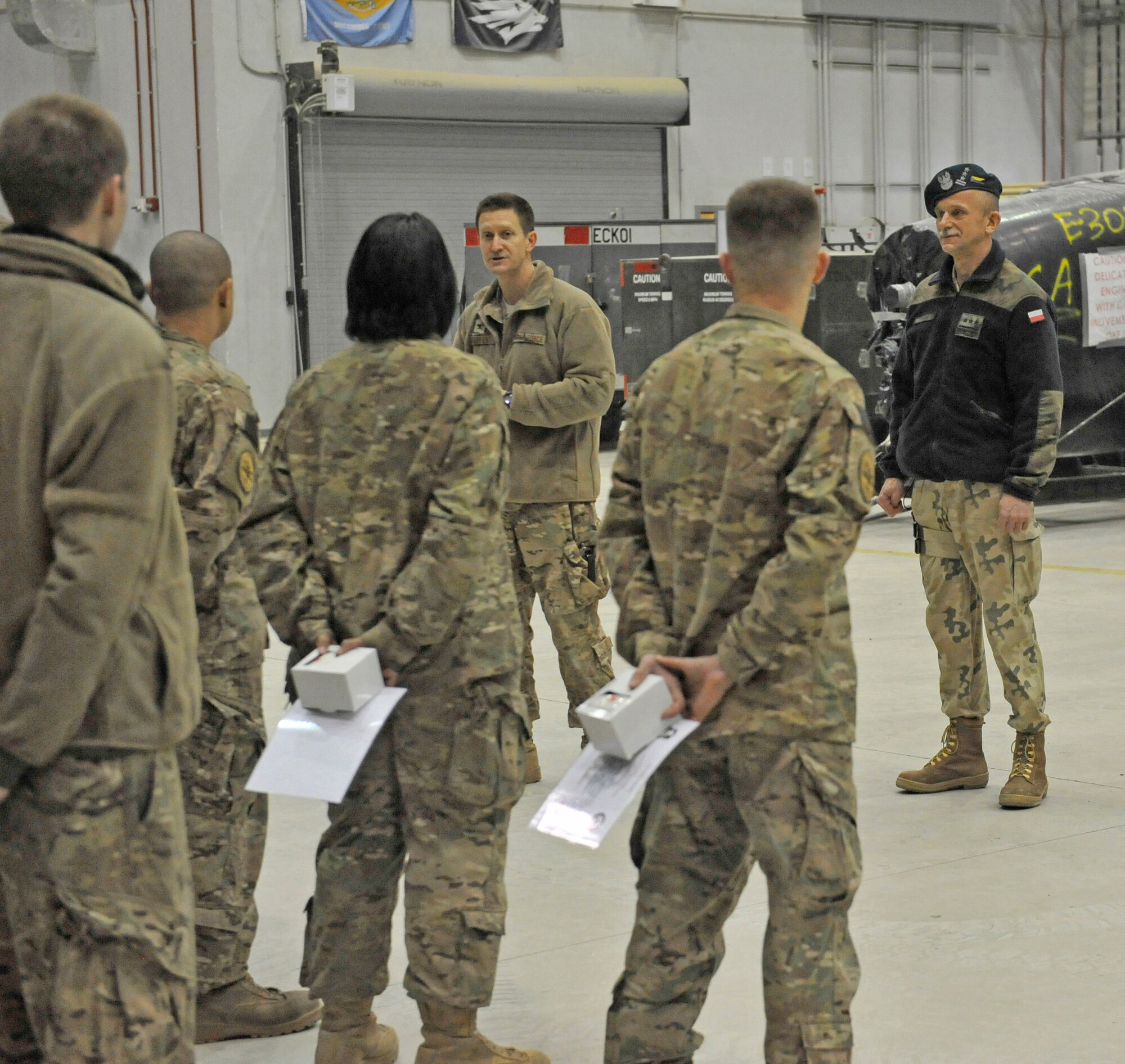 Colonel Aaron Steffens, 455th Air Expeditionary Wing vice commander, addresses members of the 455th Expeditionary Aircraft Maintenance Squadron at Bagram Airfield, Afghanistan, Jan. 3, 2013. Eight members had just received recognition from Polish Air Force Colonel Andrzej Kusnierek, International Security Assistance Force Regional Command-East deputy commanding general for coalition forces, for their role in replacing a propeller on a Polish C-130 aircraft.(U.S. Air Force photo by Senior Master Sgt. Gary J. Rihn/Released)