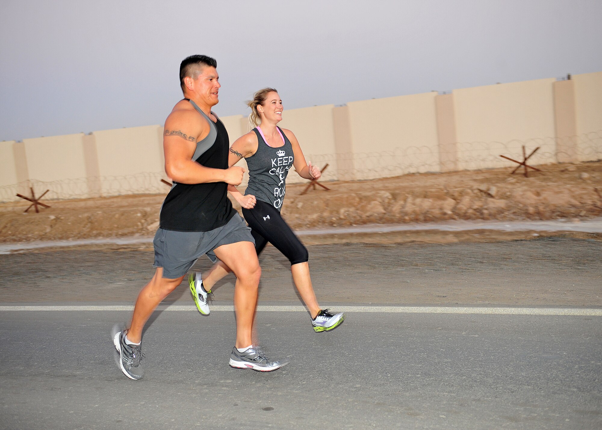 Capt. Ezekiel "E.Z." Duran, a physiologist with the 380th Expeditionary Medical Group, and Capt. Holly Brauer, 380th Air Expeditionary Wing chief of protocol, train for a marathon at an undisclosed location in Southwest Asia, Jan. 1, 2014. (U.S. Air Force photo by Staff Sgt. Michael Means/Released)
