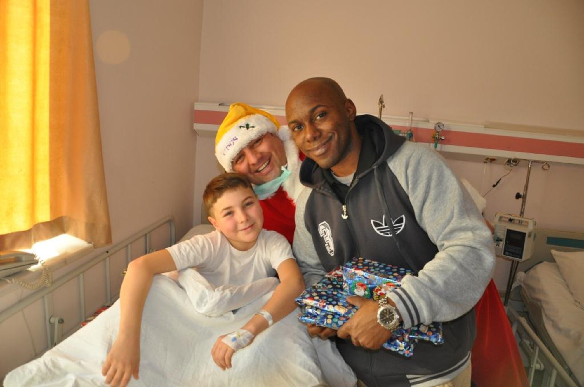 Murat Özçelik, a Vinnell-Brown and Root employee dressed in as Santa Claus, and Senior Airman Timothy Harrison, 425th Air Base Squadron security forces base defense operations center controller, pose with a Turkish boy at the surgical ward of the children’s hospital after surprising him and presenting him with giving gifts. 
(U.S. Air Force photo by Tanju Varlıklı/Released)
