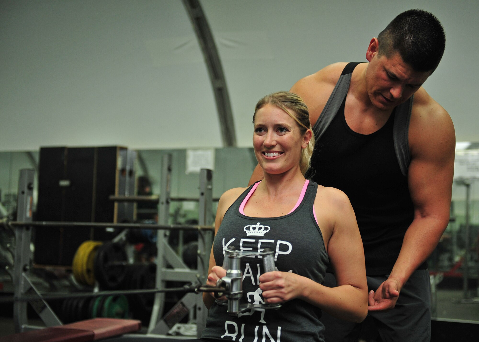 Capt. Ezekiel "E.Z." Duran, a physiologist with the 380th Expeditionary Medical Group, gives workout tips to Capt. Holly Brauer, 380th Air Expeditionary Wing chief of protocol, at an undisclosed location in Southwest Asia, Jan. 1, 2014. (U.S. Air Force photo by Staff Sgt. Michael Means/Released)