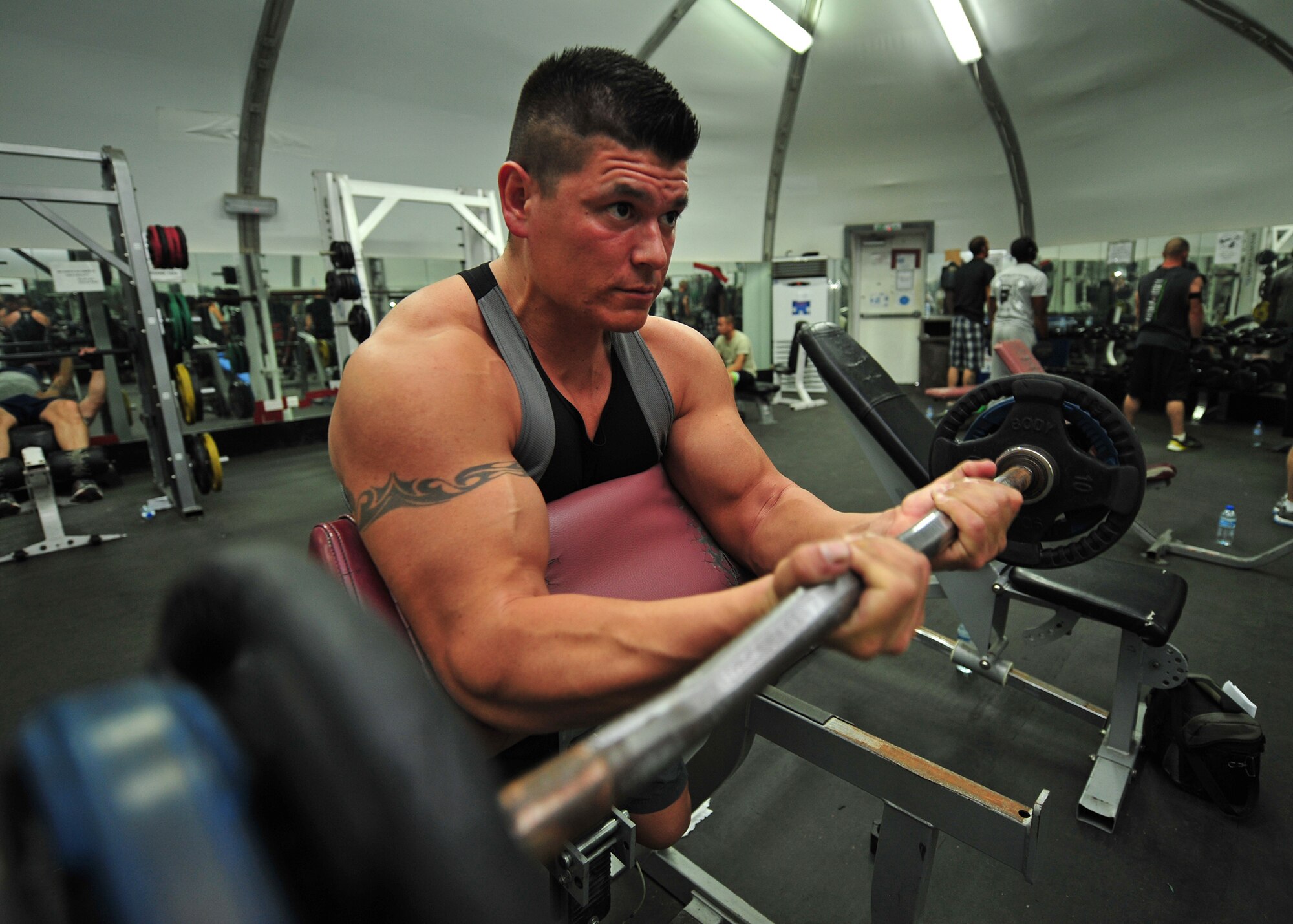 Capt. Ezekiel "E.Z." Duran, a physiologist with the 380th Expeditionary Medical Group, exercises at the base fitness center at an undisclosed location in Southwest Asia, Jan. 1, 2014. Duran works out two times a day while also training to run a marathon. (U.S. Air Force photo by Staff Sgt. Michael Means/Released)