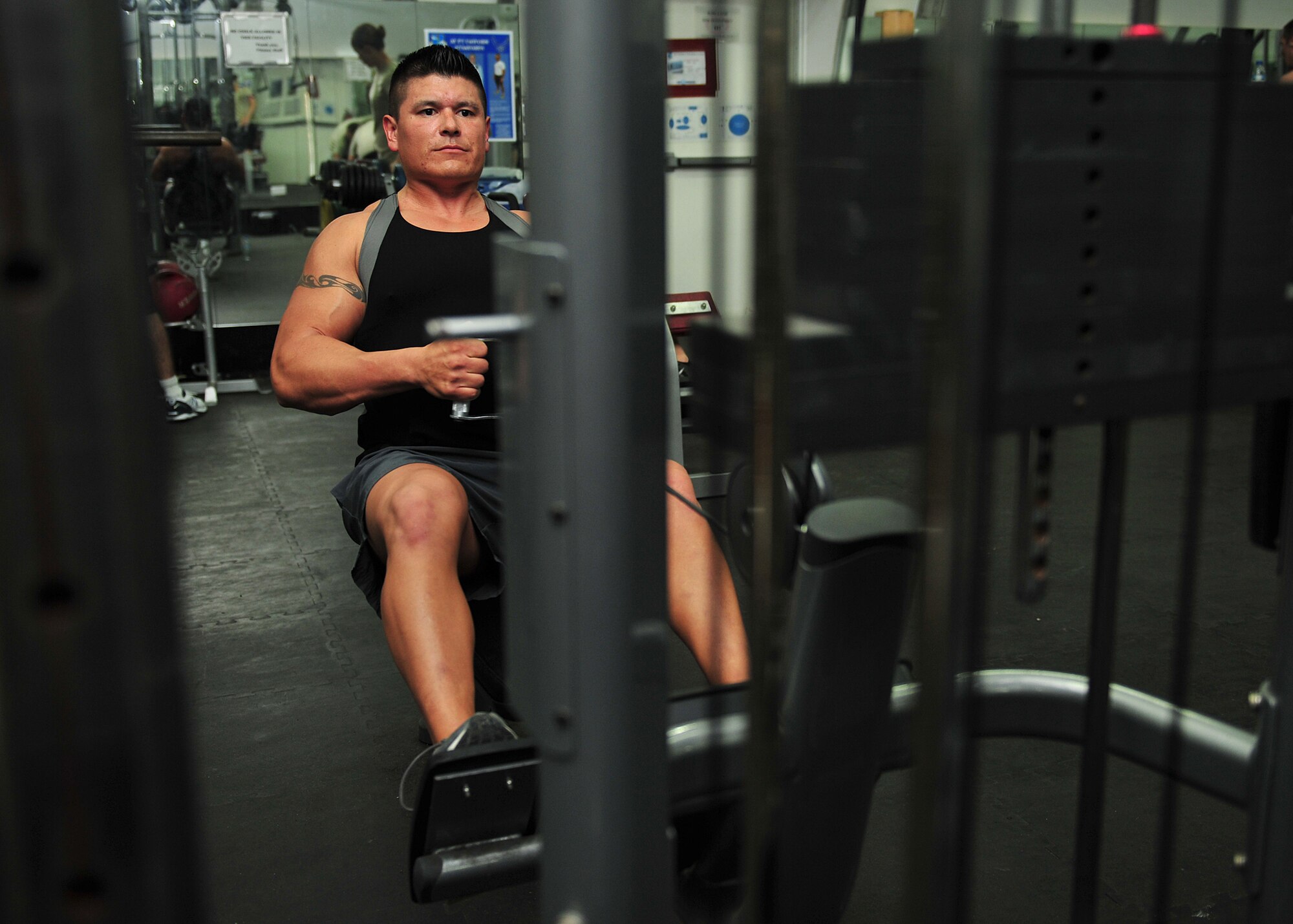 Capt. Ezekiel "E.Z." Duran, a physiologist with the 380th Expeditionary Medical Group, exercises at the base fitness center at an undisclosed location in Southwest Asia, Jan. 1, 2014. Duran works out two times a day while also training to run a marathon. (U.S. Air Force photo by Staff Sgt. Michael Means/Released)