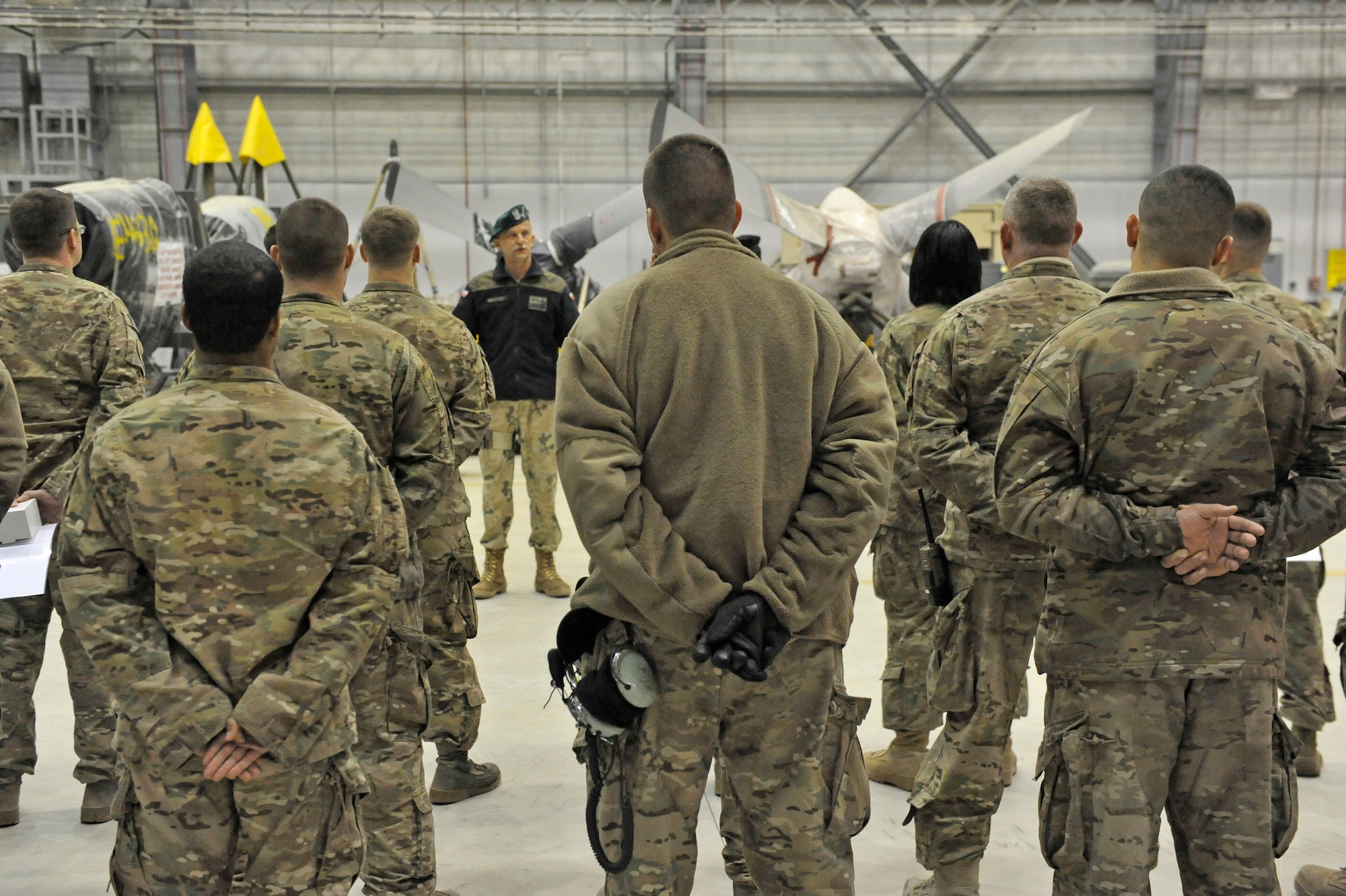 Members of the 455th Expeditionary Aircraft Maintenance Squadron listen to Polish Air Force Colonel Andrzej Kusneierek, International Security Assistance Force Regional Command-East deputy commanding general for coalition forces, at Bagram Airfield, Afghanistan, Jan. 3, 2013. Kusnierek expressed his thanks after eight members replaced a propeller on a Polish C-130 aircraft.(U.S. Air Force photo by Senior Master Sgt. Gary J. Rihn/Released)