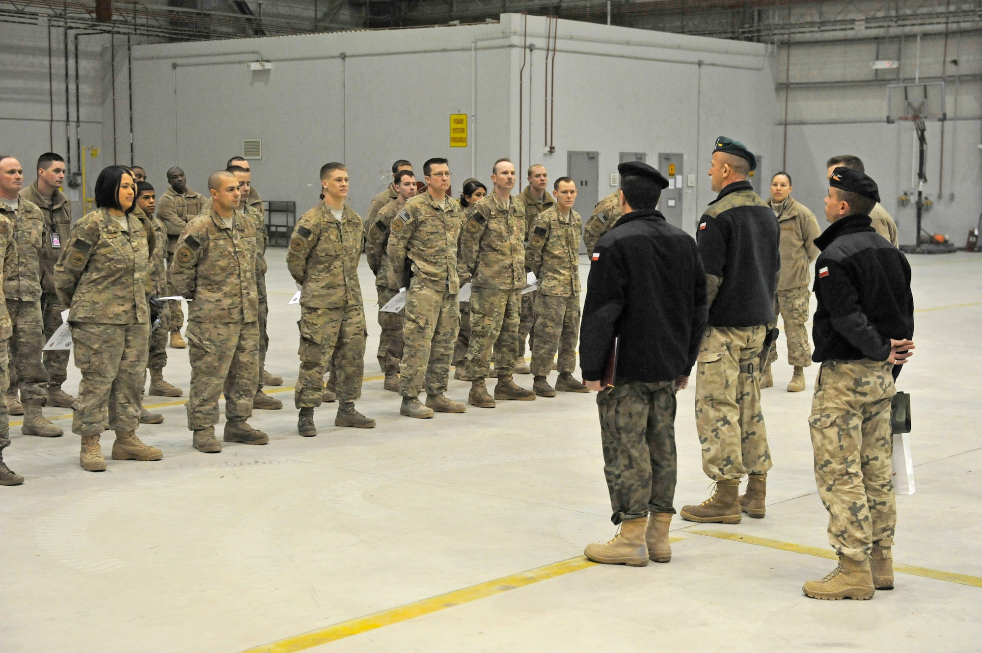 Polish Air Force Colonel Andrzej Kusnierek, International Security Assistance Force Regional Command-East deputy commanding general for coalition forces, addresses a group of 455th Expeditionary Aircraft Maintenance Squadron personnel at a ceremony on Bagram Airfield, Afghanistan, Jan. 3, 2013. Kusnierek thanked the maintainers for helping to replace a propeller on a Polish C-130 aircraft.(U.S. Air Force photo by Senior Master Sgt. Gary J. Rihn/Released)