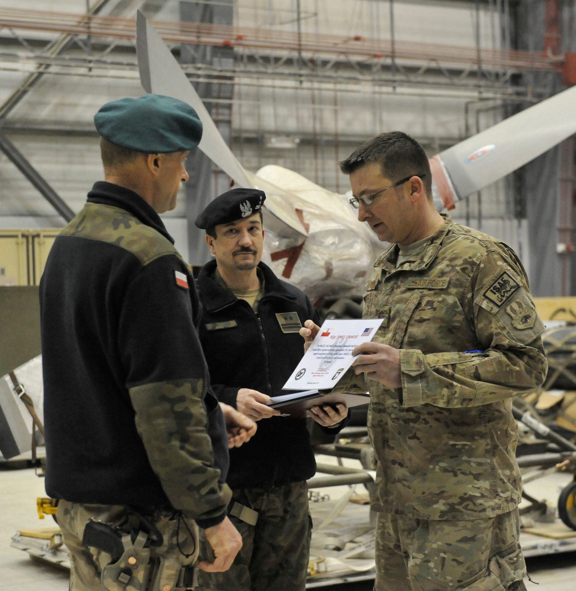 Master Sgt. James Simmons of the 455th Expeditionary Aircraft Maintenance Squadron receives appreciation from  Polish Air Force Colonel Andrzej Kusneierek, International Security Assistance Force Regional Command-East deputy commanding general for coalition forces, at Bagram Airfield, Afghanistan, Jan. 3, 2013. Simmons assisted in replacing a propeller on a Polish C-130 aircraft.(U.S. Air Force photo by Senior Master Sgt. Gary J. Rihn/Released)