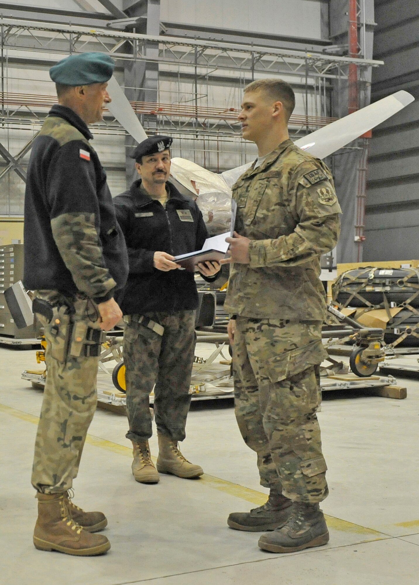 Senior Airman Zachery Gray of the 455th Expeditionary Aircraft Maintenance Squadron receives appreciation from  Polish Air Force Colonel Andrzej Kusneierek, International Security Assistance Force Regional Command-East deputy commanding general for coalition forces, at Bagram Airfield, Afghanistan, Jan. 3, 2013. Gray was part of a team that replaced a propeller on a Polish C-130 aircraft.(U.S. Air Force photo by Senior Master Sgt. Gary J. Rihn/Released)