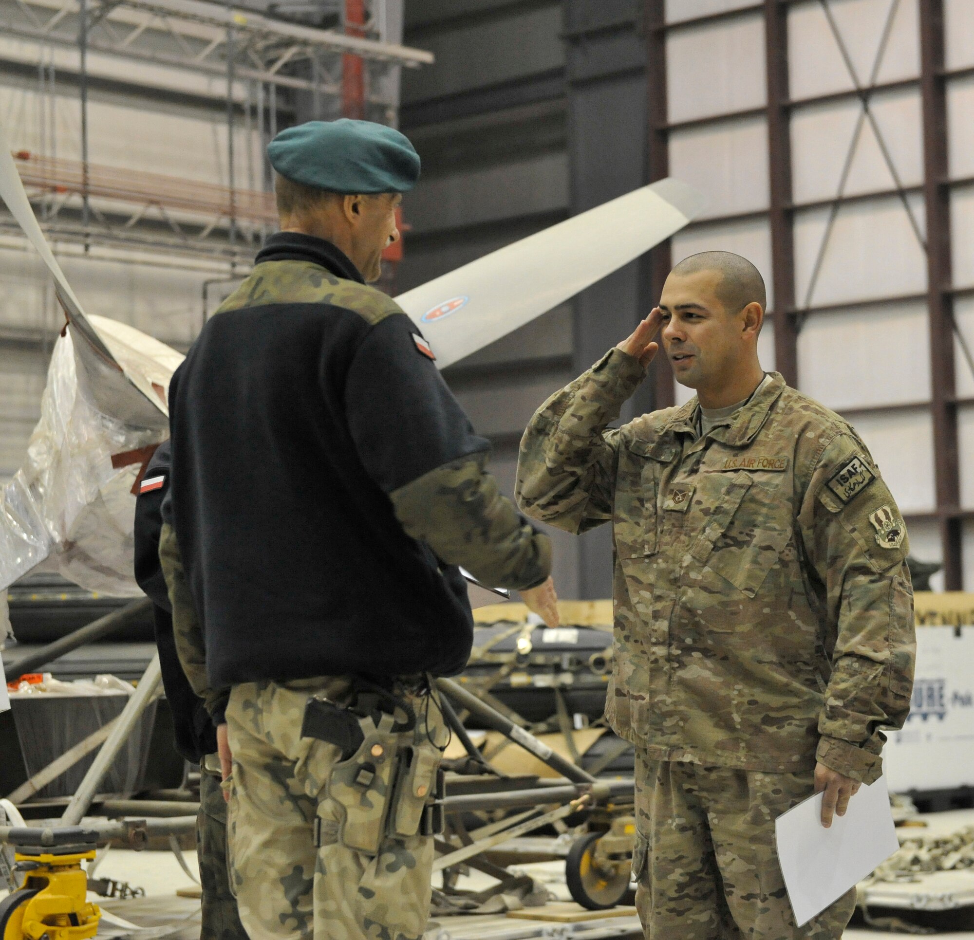 Technical Sgt. Joshua Craigo of the 455th Expeditionary Aircraft Maintenance Squadron receives appreciation from  Polish Air Force Colonel Andrzej Kusneierek, International Security Assistance Force Regional Command-East deputy commanding general for coalition forces, at Bagram Airfield, Afghanistan, Jan. 3, 2013. Craigo was commended for his role in replacing a propeller on a Polish C-130 aircraft.(U.S. Air Force photo by Senior Master Sgt. Gary J. Rihn/Released)
