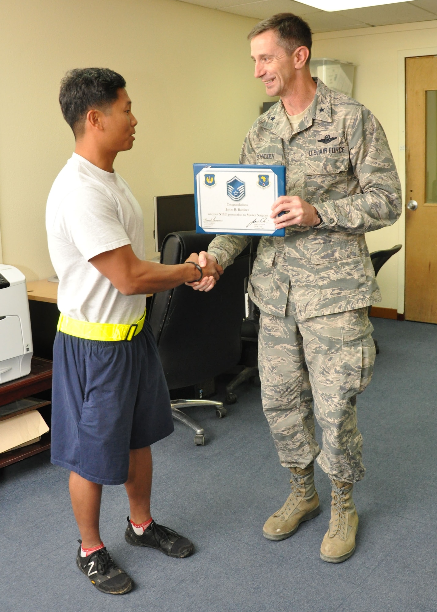 U.S. Air Force Brig. Gen. Kevin Schneider, 380th Air Expeditionary Wing commander, presents U.S. Air Force Master Sgt. Jason Ramirez, 380th Expeditionary Civil Engineer Squadron assistant chief of training, a promotion certificate Dec. 21, 2013, at a deployed location in Southwest Asia.  Ramirez received his senior NCO stripe under the Air Force’s Stripes for Exceptional Performers program. Ramirez is deployed from RAF Mildenhall, England. (U.S. Air Force photo by Tech. Sgt. Colleen Urban/Released)