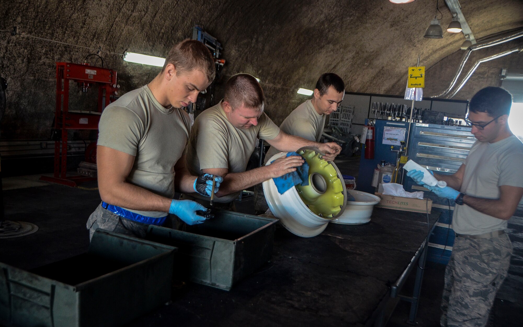 Airmen from the 379th Expeditionary Maintenance Squadron work together to fix the front wheel of a C-130J Super Hercules at the 379th Air Expeditionary Wing, Dec. 31, 2013. The shop is made up of eight Airmen who are tasked with fixing and maintaining six types of aircraft wheels on the installation. (U.S. Air Force photo/Senior Airman Jared Trimarchi)