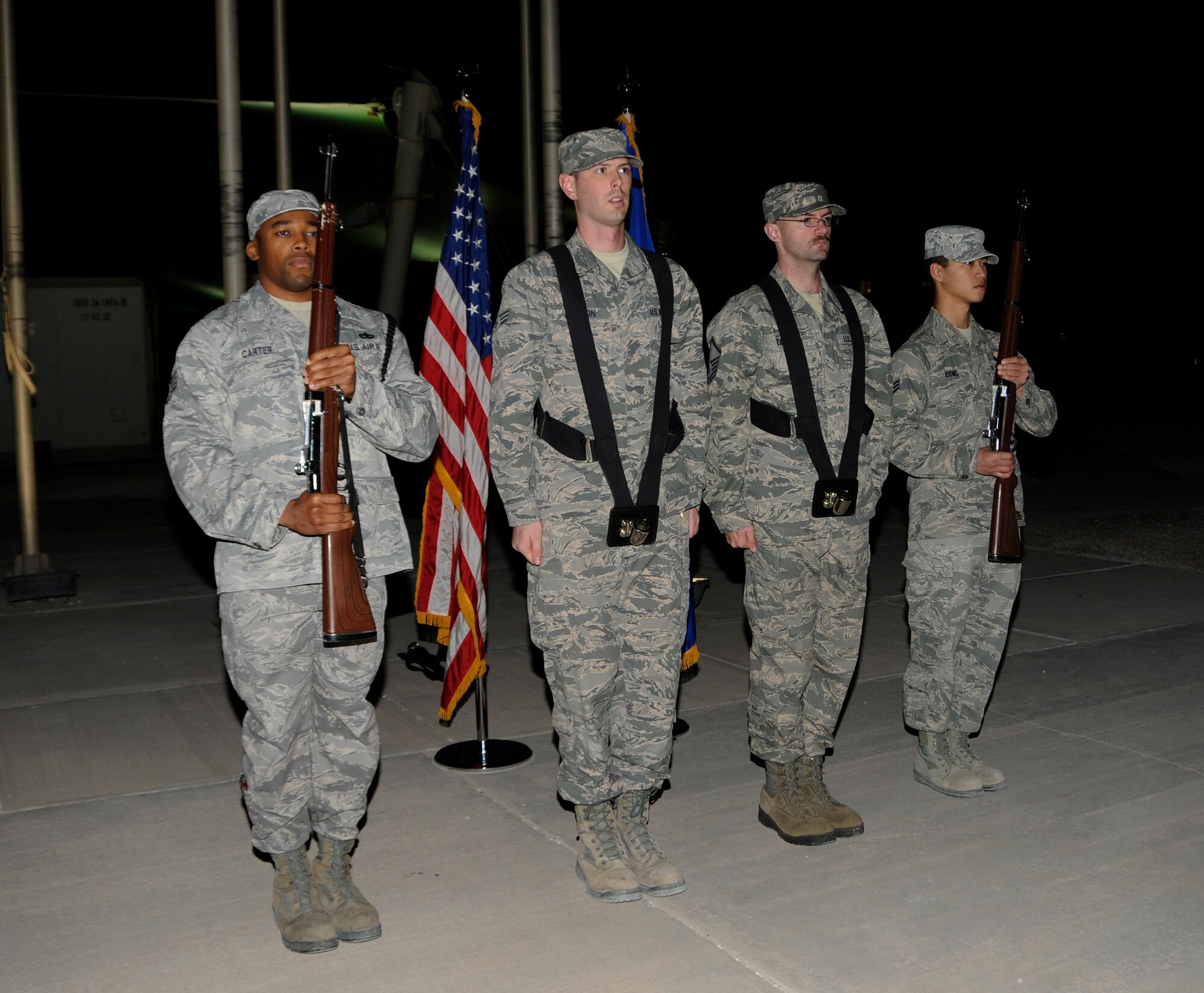 Members of the 379th Air Expeditionary Wing Honor Guard stand in formation as they prepare for practice in Southwest Asia, Jan. 2, 2014. During practice the Honor Guard works to perfect sharp, crisp and motionless bearing. The Honor Guard is made up of volunteer service members and practices two times a week to hone their skills. (U.S. Air Force photo/Senior Airman Hannah Landeros)