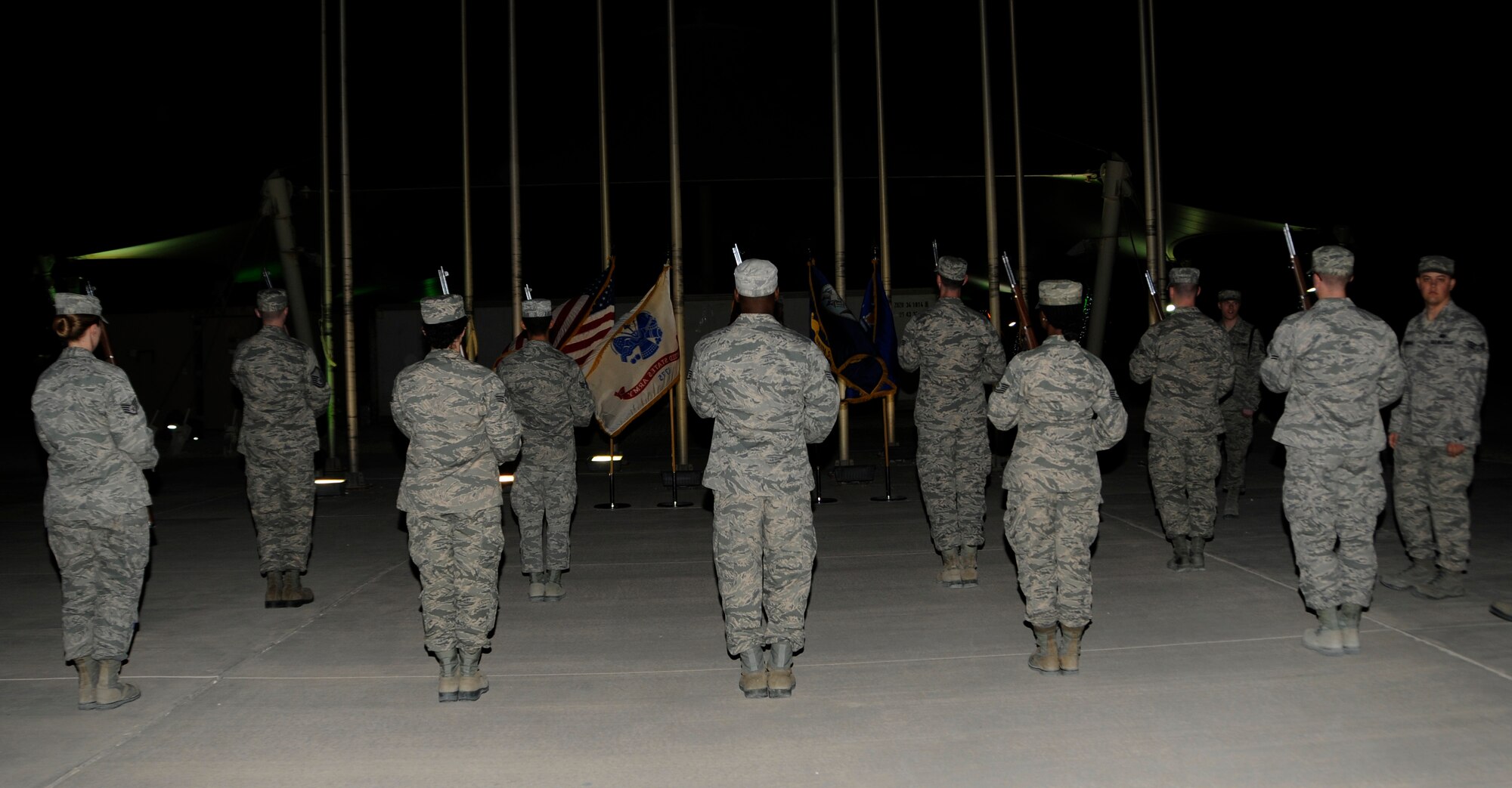 Members of the 379th Air Expeditionary Wing Honor Guard stand in formation as they prepare for practice in Southwest Asia, Jan. 2, 2014. During practice the Honor Guard works to perfect sharp, crisp and motionless bearing. The Honor Guard is made up of volunteer service members and practices two times a week to hone their skills. (U.S. Air Force photo/Senior Airman Hannah Landeros)