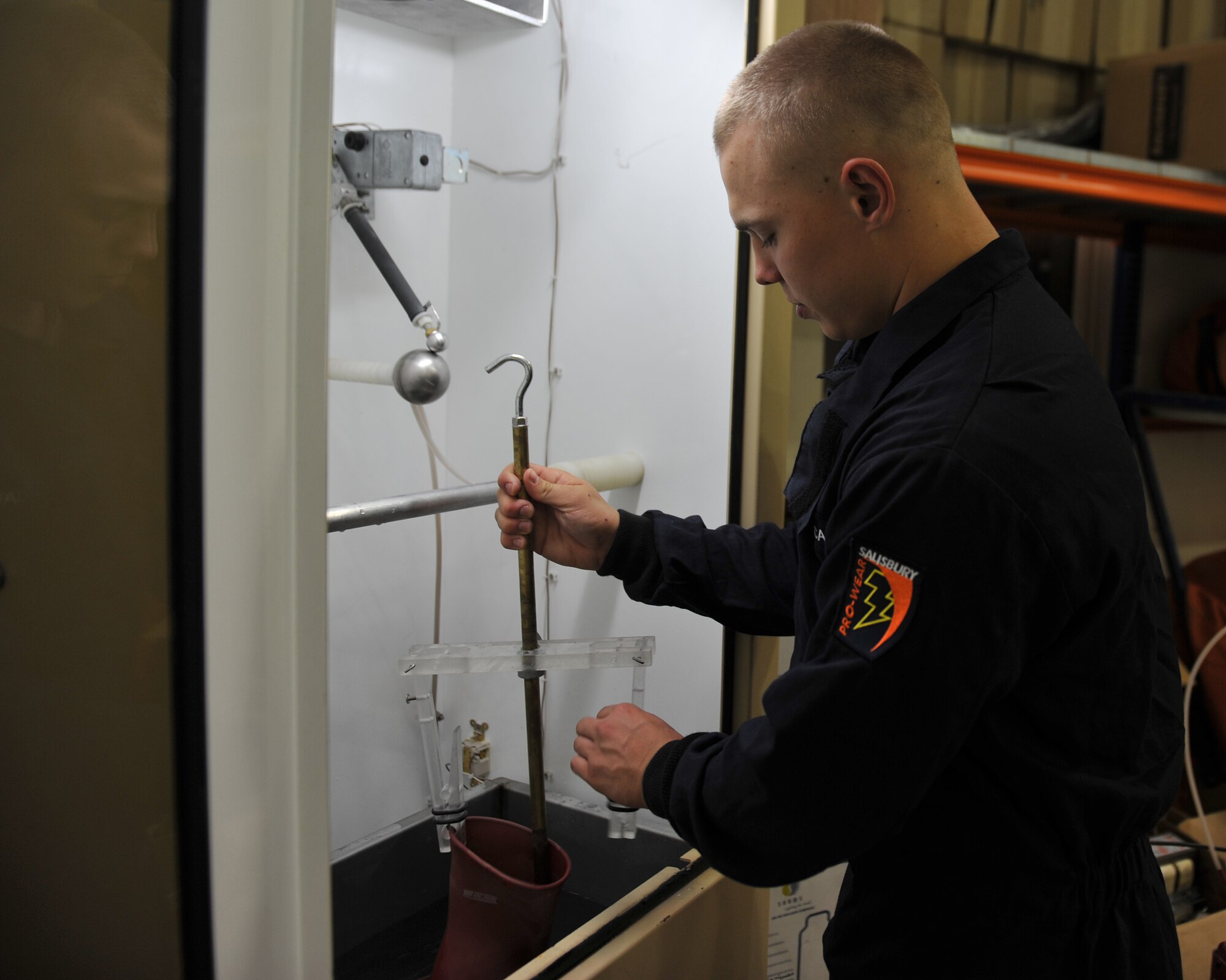Senior Airman Justin Henke removes a glove from the electrical tester after testing at the 379th Air Expeditionary Wing, Southwest Asia, Dec. 30, 2013. Henke has tested 62 pairs of gloves since Dec. 23 which is a requirement for all gloves received and in current inventory. Gloves used daily are tested every six months or sooner if a glove is turned in for inspection. Henke is a 379th Expeditionary Civil Engineer Squadron electrical systems journeyman deployed from Ramstein Air Base, Germany and a Vicksburg, Miss., native. (U.S. Air Force photo by Master Sgt. David Miller)