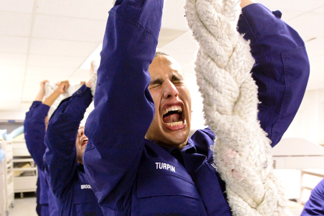 U.S. Coast Guard Seaman Recruit Tyler Turpin conducts remedial line handling at Training Center Cape May, N.J., Dec. 31, 2013. The recruits must press the 150-pound towing hawser above their heads while reciting the Coast Guard's Core Values of Honor, Respect and Devotion to Duty. 
