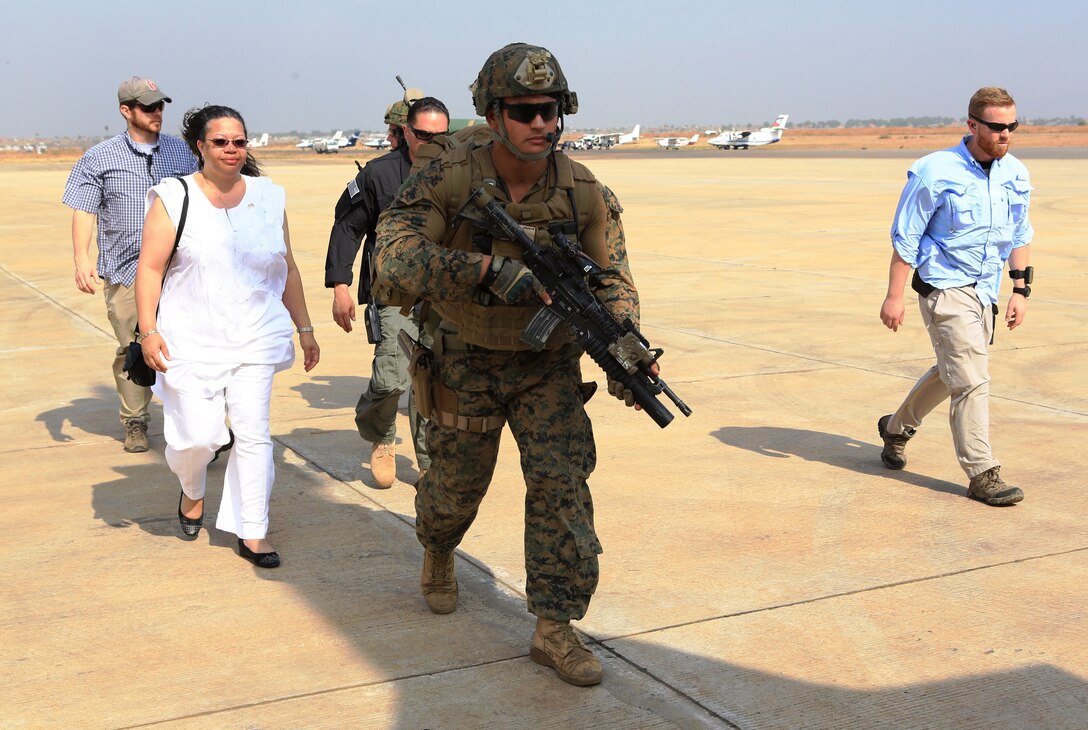 U.S. Marine Corps Sgt. Andrew Rodriguez, leads Susan D. Page, U.S. ambassador to South Sudan, down the flight line in Juba, South Sudan, during an evacuation of personnel from the U.S. Embassy, Jan. 3, 2014. Rodriguez, is a team leader assigned to the Special-Purpose Marine Air-Ground Task Force Crisis Response. 