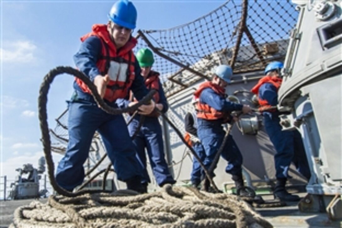 U.S. Navy Petty Officer 3rd Class Corey Krum, left, coils a line aboard the guided-missile cruiser USS San Jacinto during a replenishment at sea in the Arabian Gulf, Dec. 28, 2013. The San Jacinto is deployed as part of the Harry S. Truman Carrier Strike Group supporting maritime security operations and theater security cooperation efforts in the U.S. 5th Fleet area of responsibility.