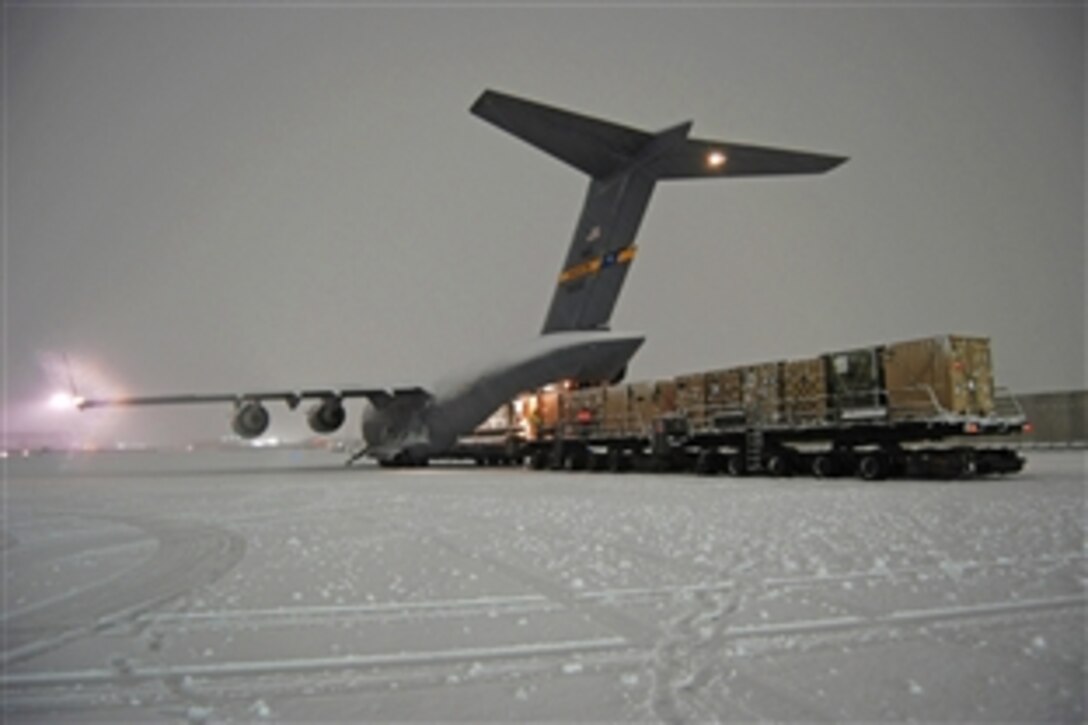 Airmen from the 455th Expeditionary Aerial Port Squadron load a C-17 Globemaster III on Bagram Airfield, Afghanistan, Dec. 29, 2013. The aircrew and aerial port airmen offloaded and loaded vehicles and cargo during a snowstorm. 