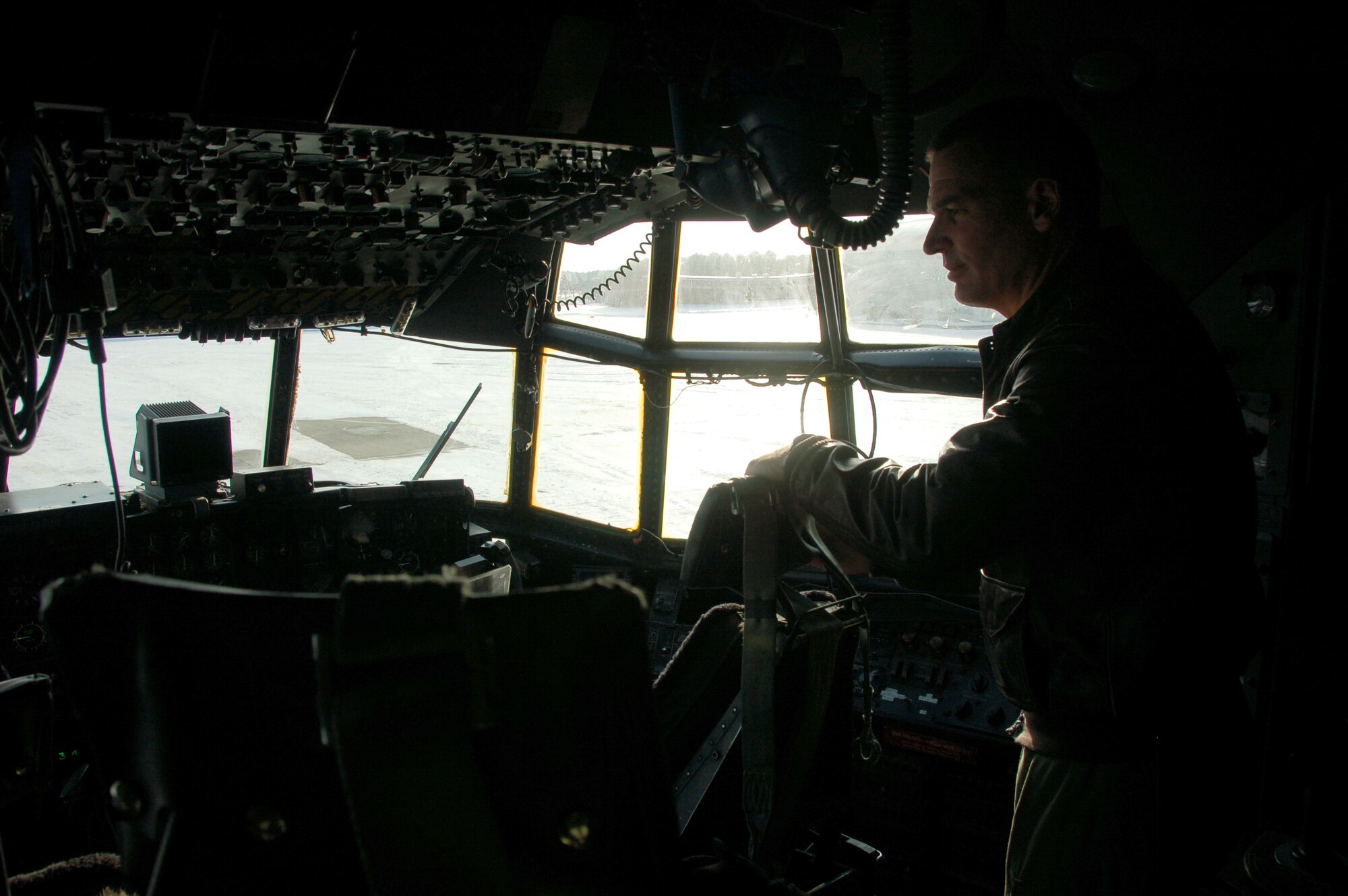 Col. Frank Detorie, commander of the 103rd Airlift Wing, peers out the window of a C-130H Hercules aircraft Dec. 19, 2013, on the ramp at Bradley Air National Guard Base, East Granby, Conn., as he waits for the inbound aircrew scheduled to launch the first locally-generated sortie with the unit’s new airframe. (U.S. Air National Guard photo by Maj. Bryon Turner)