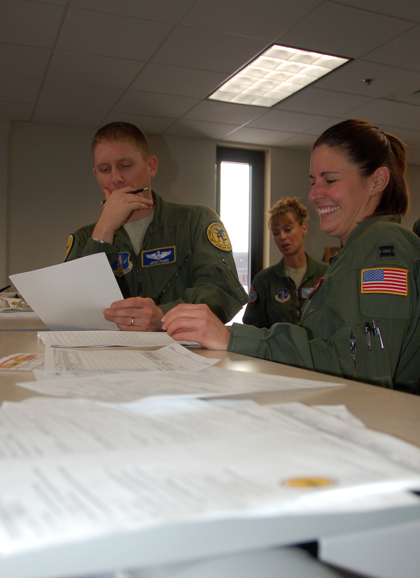 Maj. Josh Panis, a pilot assigned to the 118th Airlift Squadron, Capt. Rachel Leimbach, a navigator assigned to the 139th Airlift Squadron and Master Sgt. Jean Booth, a loadmaster assigned to the 139th Airlift Squadron, go over final preparations before embarking on the first locally-generated sortie aboard a C-130H Hercules aircraft Dec. 19, 2013, at Bradley Air National Guard Base, East Granby, Conn.  The aircrew was comprised of Airmen from the Connecticut Air National Guard, the New York Air National Guard and the U.S.A.F.  (U.S. Air National Guard photo by Maj. Bryon Turner)