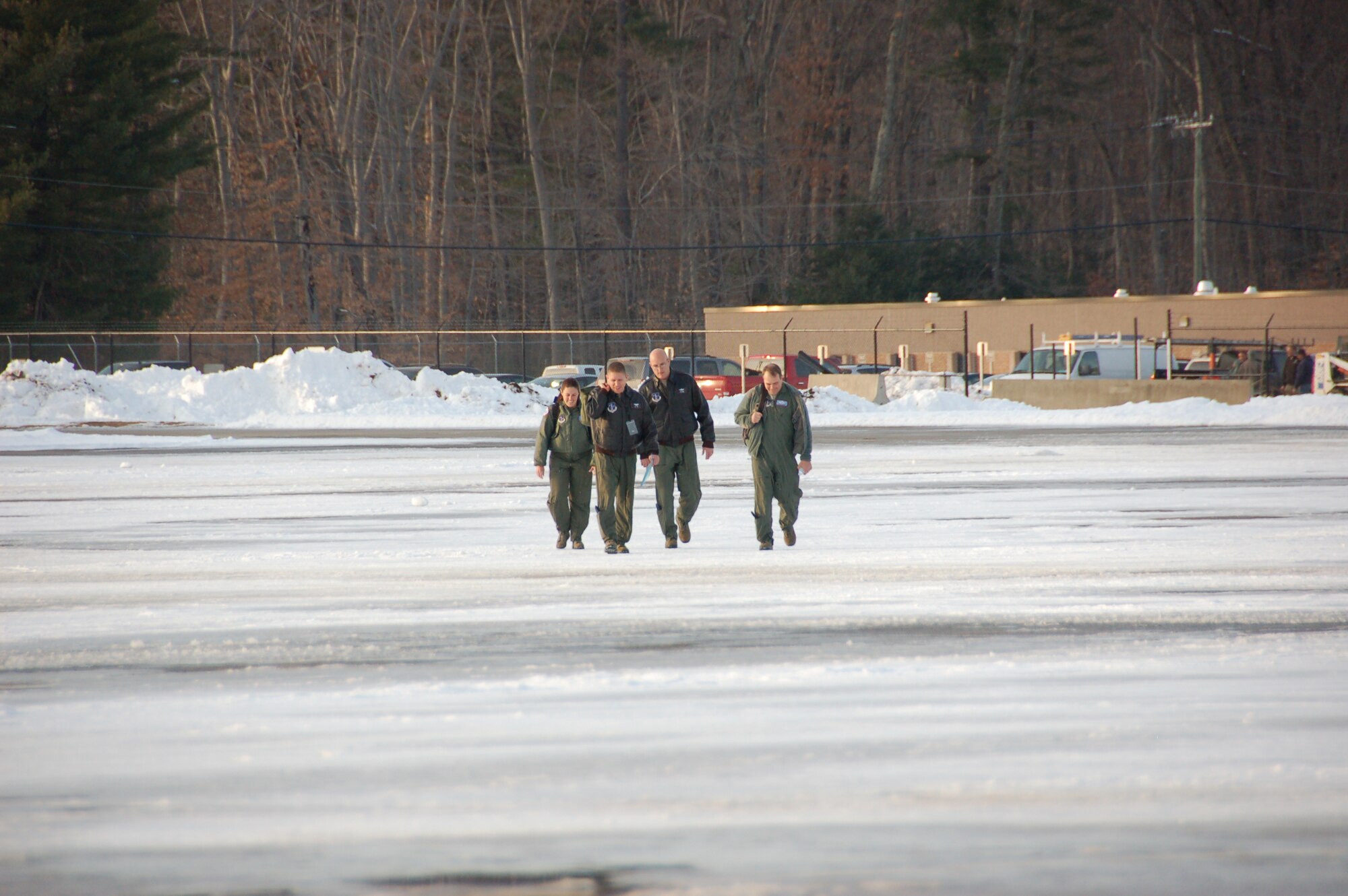 Capt. Rachel Leimbach, a navigator assigned to the 139th Airlift Squadron, Maj. Josh Panis, a pilot assigned to the 118th Airlift Squadron, Lt. Col. Kenneth LaTona, acting commander of the 103rd Operations Group and Lt. Col. Steve Yandik, aircraft commander from the 139th Airlift Squadron, walk across a wintery flightline moments before the launch of the first locally-generated sortie aboard a C-130H Hercules aircraft Dec. 19, 2013, at Bradley Air National Guard Base, East Granby, Conn.  The aircrew was comprised of Airmen from the Connecticut Air National Guard, the New York Air National Guard and the U.S.A.F.  (U.S. Air National Guard photo by Maj. Bryon Turner)