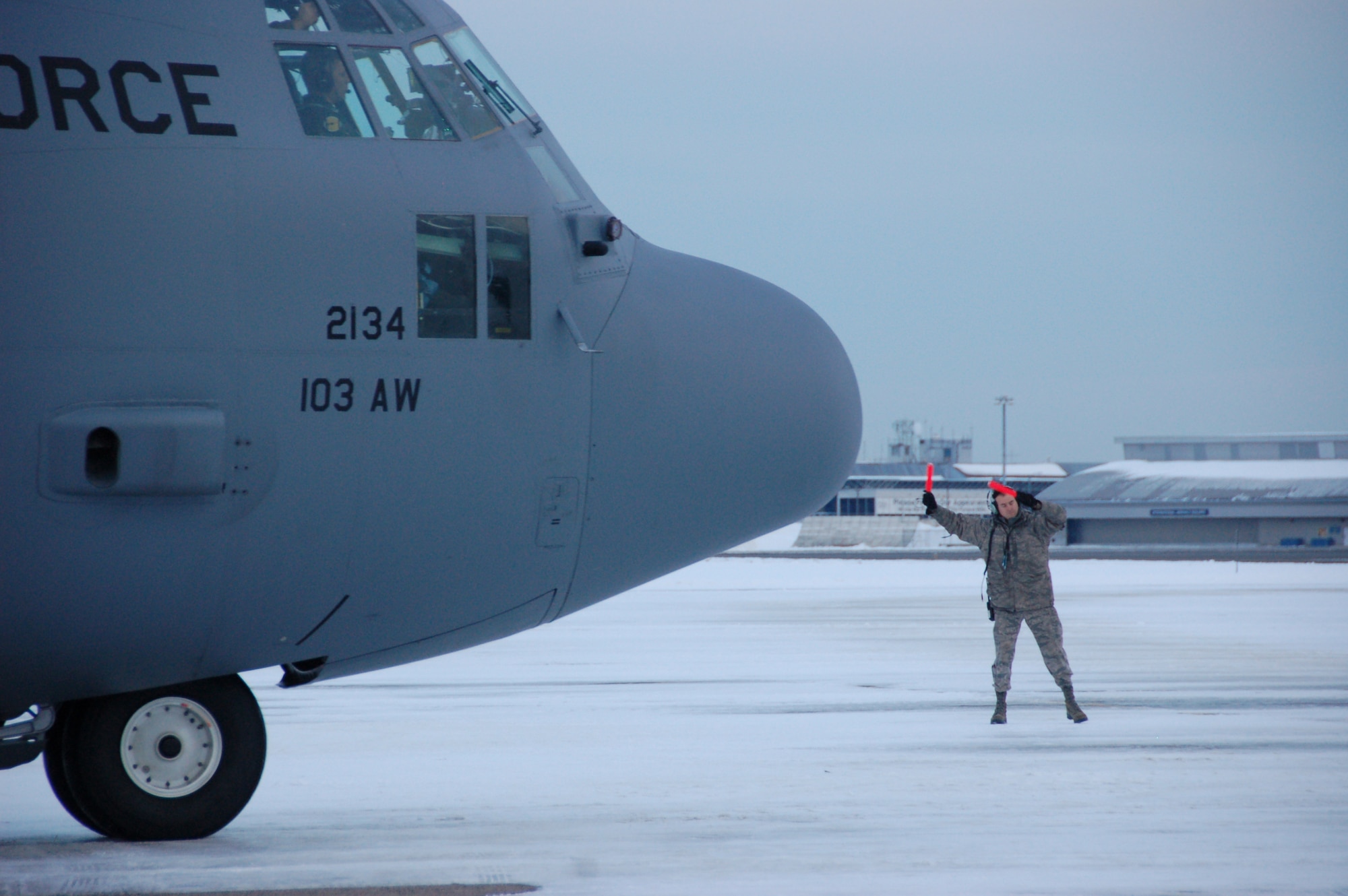 Master Sgt. Jon Favreau, a crew chief assigned to the 103rd Maintenance Group, guides a C-130H Hercules aircraft assigned to the 103rd Airlift Wing toward the runway moments before the first locally-generated sortie with the unit’s new airframe at Bradley Air National Guard Base, East Granby, Conn., Dec. 19, 2013.  The aircrew was comprised of Airmen from the Connecticut Air National Guard, the New York Air National Guard and the U.S.A.F.  (U.S. Air National Guard photo by Maj. Bryon Turner)