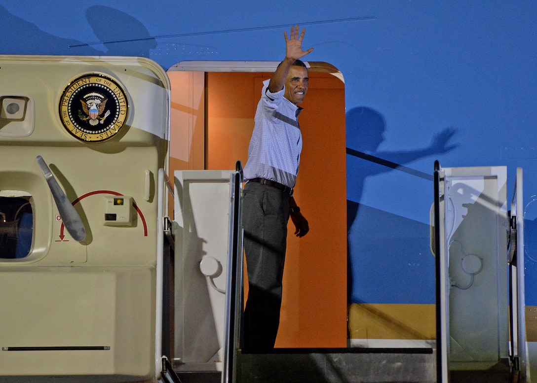 President of the United States Barack Obama waves to servicemembers and their families at Joint Base Pearl Harbor-Hickam, Hawaii, while boarding Air Force One, Jan. 4, 2014. President Obama and daughters Sasha and Malia are on their way back to Washington D.C., after a 15-day family vacation for the holidays. (U.S. Air Force photo/Staff Sgt. Alex Martinez)