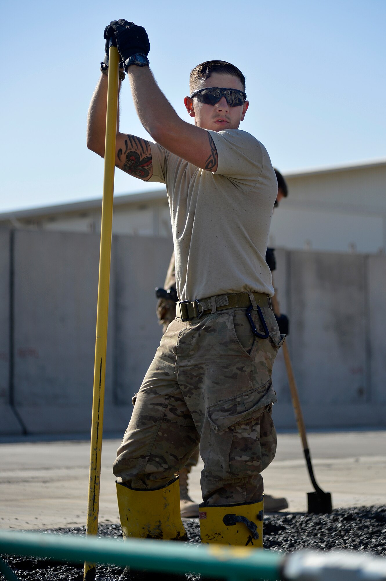 U.S. Air Force Senior Airman Dylan Sheets, 577th Expeditionary Prime BEEF Squadron heating, ventilation, and air conditioning specialist, takes a break from raking concrete at Kandahar Airfield, Afghanistan, Jan. 4, 2014. The 577th EPBS is forward deployed from the 1st Expeditionary Civil Engineer Group at Al Udeid Air Base. (U.S. Air Force photo by Senior Airman Kayla Newman/Released)