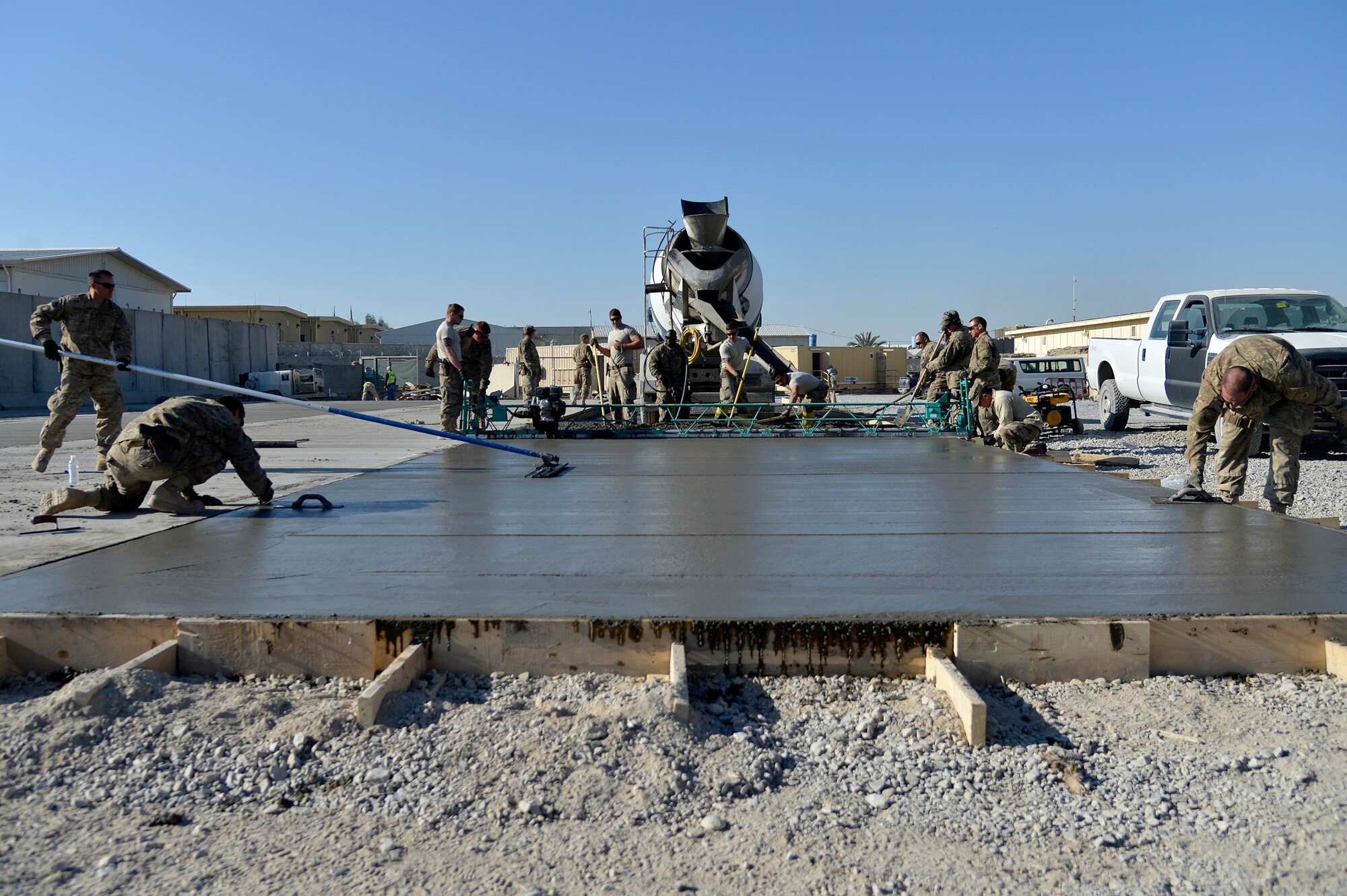 U.S. Air Force Airmen assigned to the 577th Expeditionary Prime BEEF Squadron pour concrete at Kandahar Airfield, Afghanistan, Jan. 4, 2014. The 577th EPBS is forward deployed from the 1st Expeditionary Civil Engineer Group at Al Udeid Air Base. (U.S. Air Force photo by Senior Airman Kayla Newman/Released)