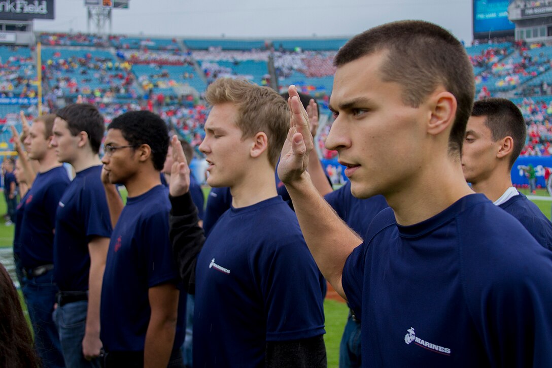 JACKSONVILLE, FLA. – Future Marines from Recruiting Station Jacksonville raise their right hands during a swearing-in ceremony on EverBank Field during the 2014 Gator Bowl Pre-Game show here Jan. 1, 2014. The ceremony was conducting in front of thousands of cheering Florida and Georgia University fans and symbolized the final step of enlistment for the young men and women headed to boot camp. (Official Marine Corps photo by Lance Cpl. John-Paul Imbody)