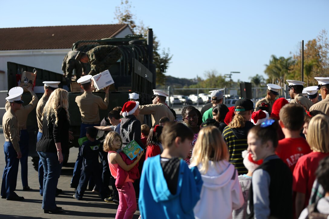 Marines with Marine Aircraft Group (MAG) 39 place donated goods in the back of an MK27 extended cargo truck with the assistance of students from Carillo Elementary School, Dec. 20. The school donated food, toys, clothing and other lightly used goods to the Marines from MAG-39 for Marine families in need.


