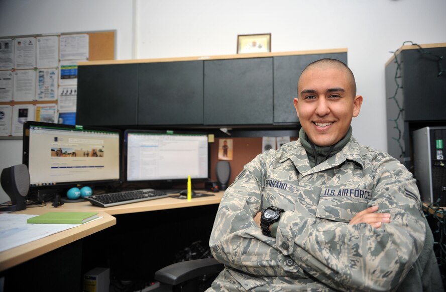 Airman 1st Class Nicholas Serrano, 51st Aircraft Maintenance Squadron knowledge operations manager, poses in front of his desk at Osan Air Base, Republic of Korea, Dec. 19, 2013. Serrano is this week's Airman Spotlight winner. (U.S. Air Force photo/Airman 1st Class Ashley J. Thum)