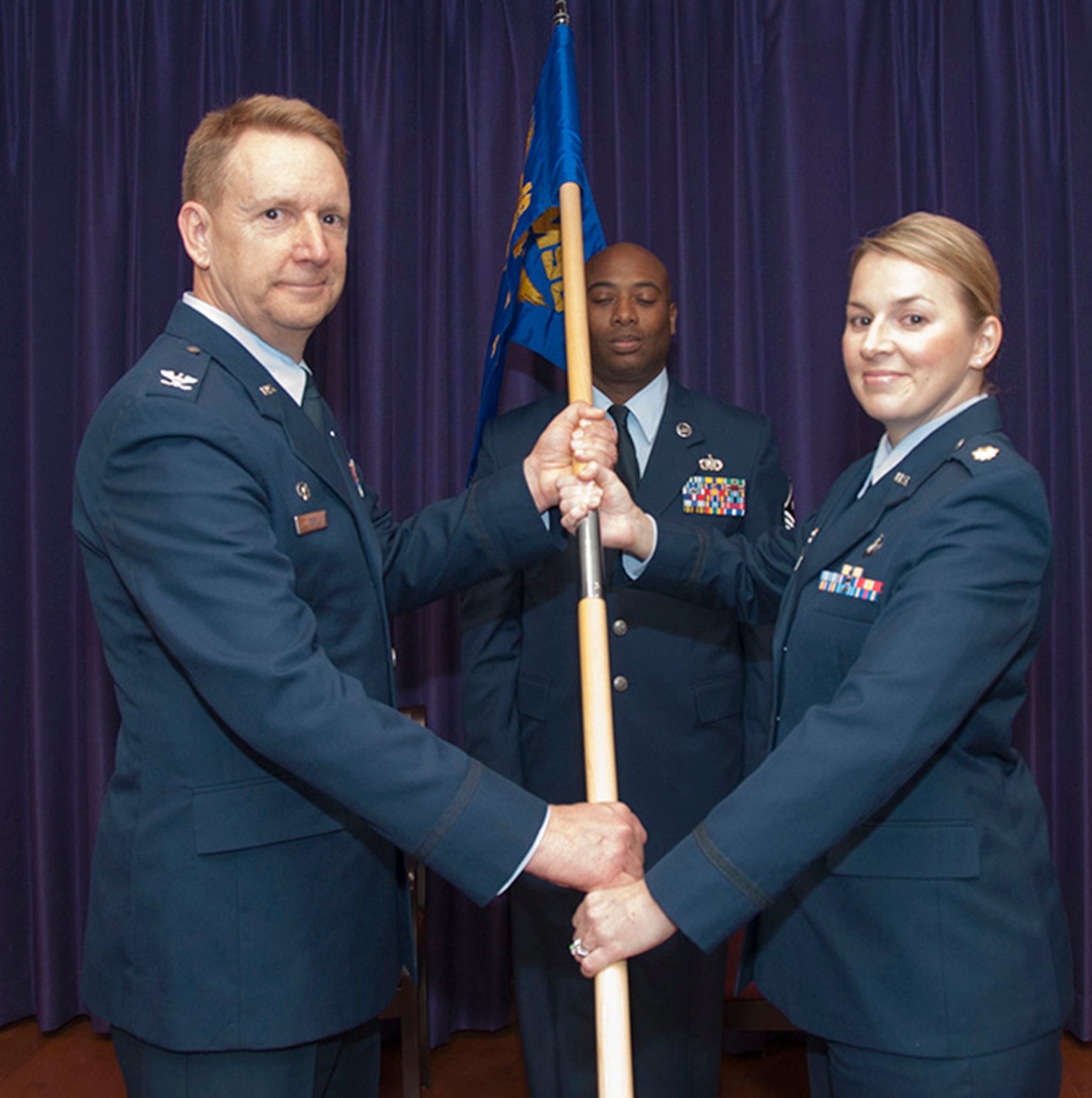 TRAVIS AIR FORCE BASE, Calif. -- Maj Erin Floersch receives the 349th Memorial Affairs Squadron guidon during an assumption of command ceremony officiated by Col. Stuart Toft, 349th Mission Support Group commander, Jan. 5.   Floersch officially took command of the squadron Nov. 2, 2013.