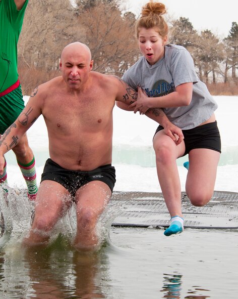 Lanie Moreau hangs onto the arm of her father, Master Sgt. Jay Moreau, 90th Civil Engineer Squadron Emergency Management Flight, as they plunge into the icy waters of Sloan Lake, Cheyenne, Wyo. during the second-annual Matthew S. Schwartz Memorial Polar Plunge Jan. 4, 2013. Participants braved 16-degree air, and 30-degree water, temperatures to raise money for a foundation which helps wounded explosive ordnance technicians and their families. The event is named for an F.E. Warren Air Force Base, Wyo., 90th CES explosive ordnance technician who was killed in action while deployed to Afghanistan Jan. 5, 2012. (U.S. Air Force photo by R.J. Oriez) 