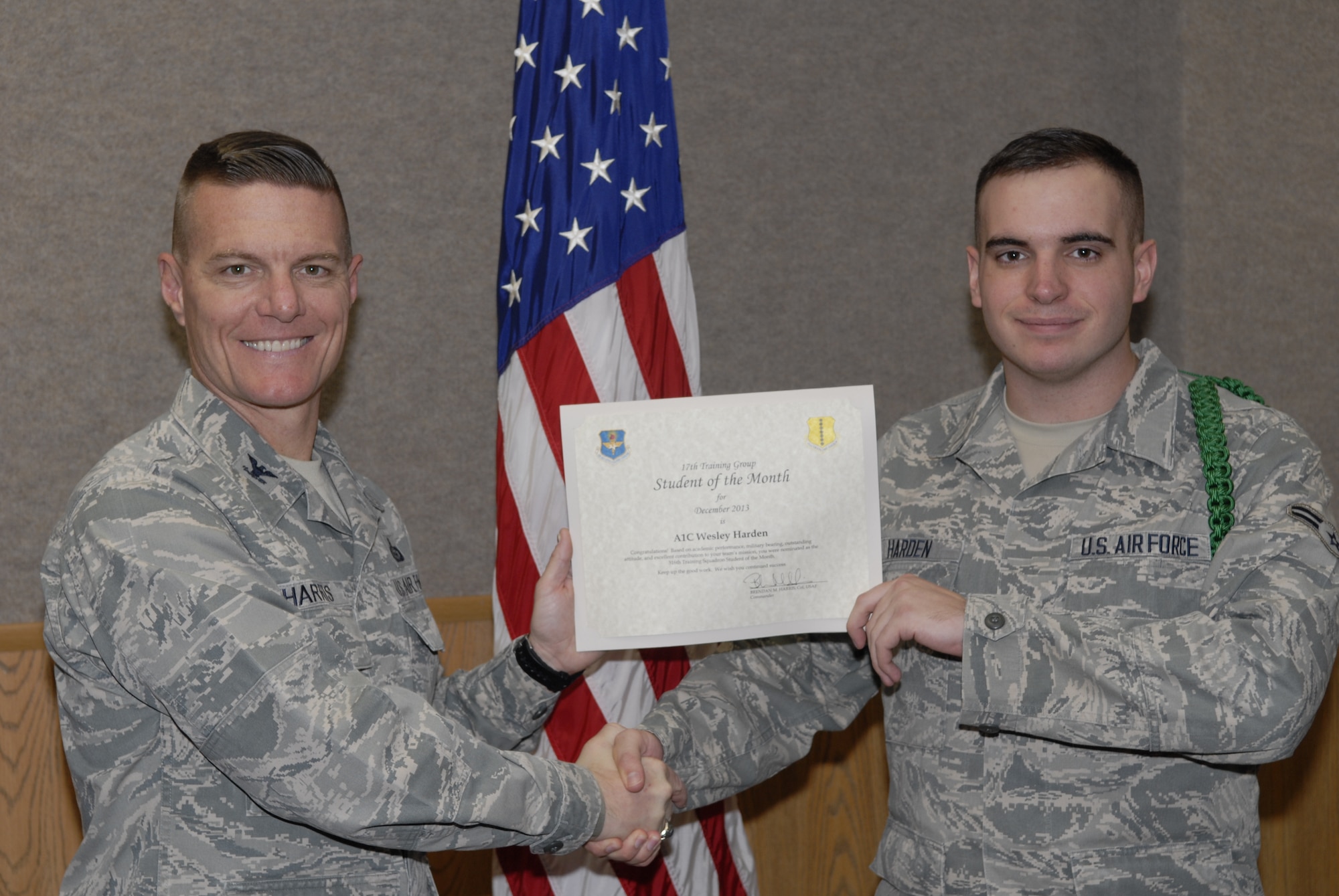 GOODFELLOW AIR FORCE BASE, Texas -- Col. Brendan Harris, 17th Training Group Commander, presents the 316th Training Squadron Enlisted Student of the Month award for December 2013 to Airman 1st Class Wesley T. Harden Jan. 3. (U.S. Air Force photo/ Lucian Czarnecki)