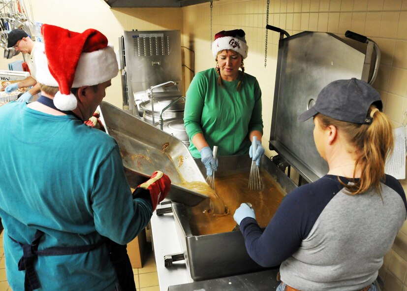 Senior Master Sgt. James Kerner, Senior Master Sgt. Nicole Gardner and Senior Master Sgt. Ruth Mortag prepare gravy at the 120th Fighter Wing Dining Facility on Dec. 24 for the 21st annual Danny Berg Memorial Christmas Dinner to be held at the Great Falls Senior Citizens Center.  National Guard photo/Senior Master Sgt. Eric Peterson.

