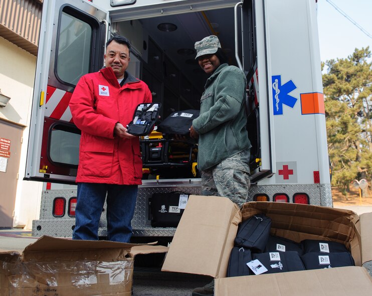 Tech. Sgt. Vivianne Jean-Pierre, 8th Medical Operations Squadron, right, accepts approximately 20 donated comfort kits from Akinori Tsuchida, American Red Cross representative, at Kunsan Air Base, Republic of Korea, Jan. 6, 2014. The Red Cross donated comfort kits, which will be provided to service members requiring an overnight hospital stay off-base to the Wolf Pack. The kits contain toiletries and clothing that make an off-base stay easier. (U.S. Air Force photo by Senior Airman Armando A. Schwier-Morales/Released)