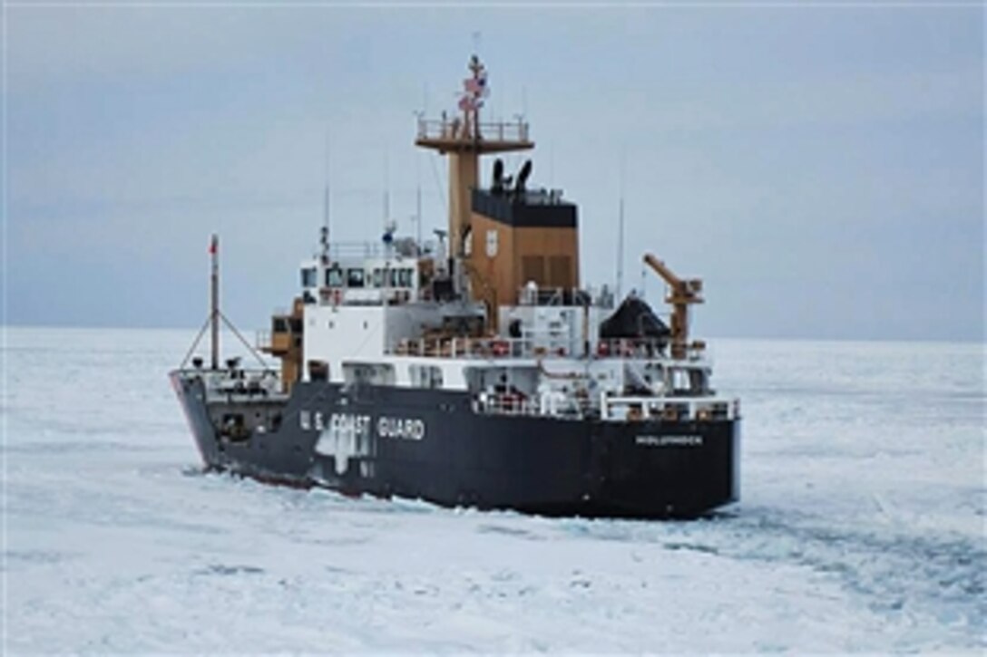 The Coast Guard Cutter Hollyhock breaks through ice as it transits to St. Ignace, Mich., for damage assessment following a collision on Lake Michigan, Jan. 5, 2014. 