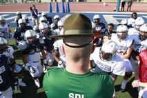 Sgt. Brian Craddock, drill instructor at Marine Corps Recruit Depot, San Diego, Calif. speaks with players of the Semper Fidelis All-American East Team at Fulerton College, Jan. 2, 2014. The Semper Fidelis All-American Bowl will be held on Jan. 5, 2014, at 6 p.m. PST in Carson, Calif., at The StubHub Center and aired live on Fox Sports 1. (Official U.S. Marine Corps photo by Sgt. Andres J. Lugo/Released)