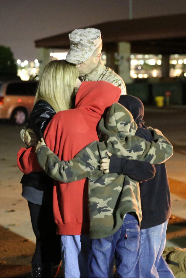 A Marine with I Marine Expeditionary Force (Forward) hugs his family as he waits to depart Camp Pendleton, Calif., to deploy to Afghanistan, Jan. 4, 2014. He is one of approximately 300 Marines and sailors who make up the I MEF (Fwd) command element deploying to Camp Leatherneck, Afghanistan, in support of Operation Enduring Freedom. I MEF (Fwd) is scheduled to return from deployment at the end of 2014 and is the last major Marine command to deploy to Afghanistan in support of OEF.