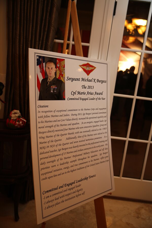 A poster displayed announces the Committed and Engaged Leader of the Year and recipient of the first Cpl. Mario Arias Award at a holiday party aboard Marine Corps Air Station Miramar, Calif., Dec. 6. Major General Steven Busby, commanding general of 3rd Marine Aircraft Wing (MAW), hosted the party to bring people together to recognize committed and engaged spouses and leaders.