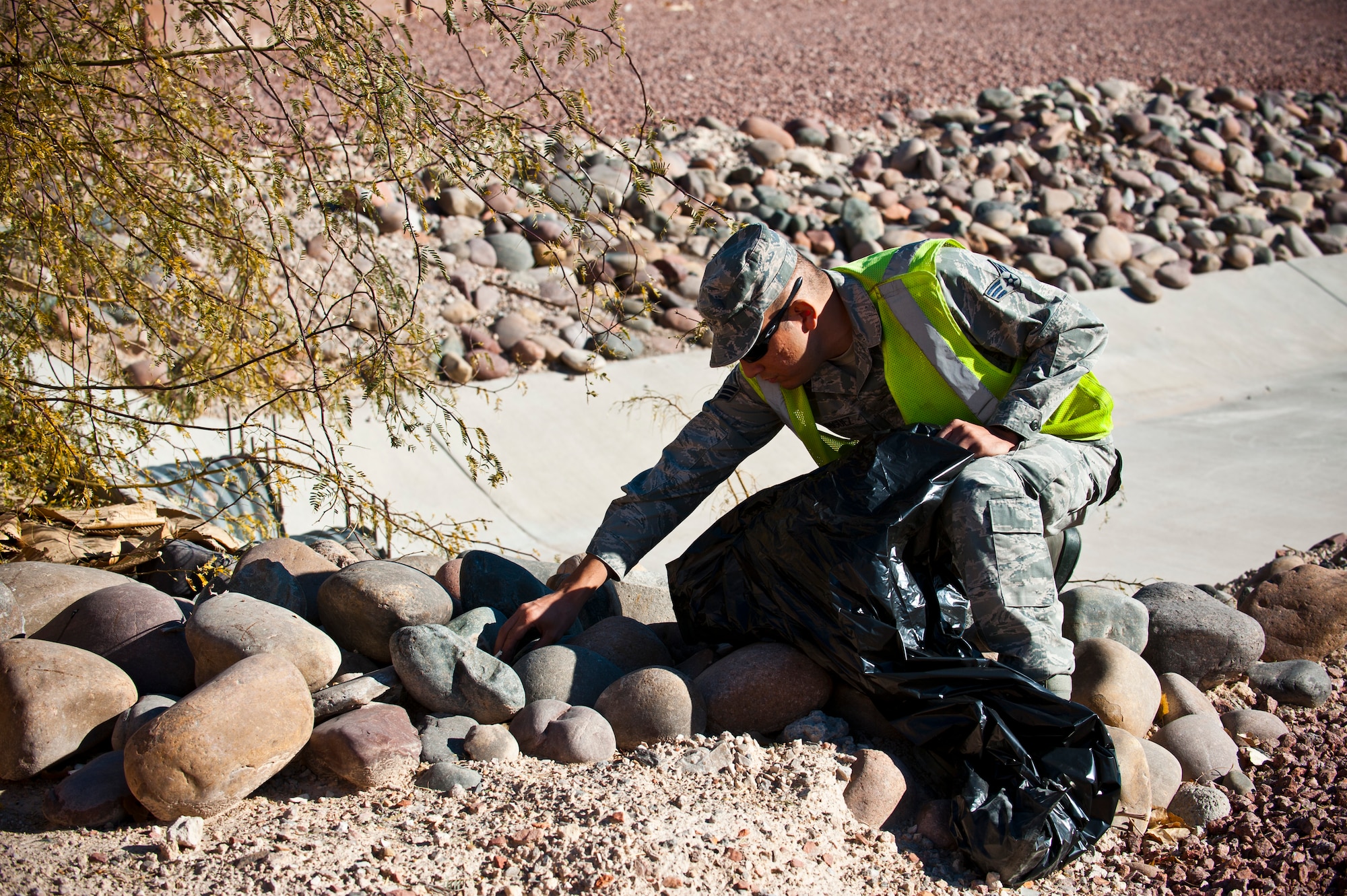 Senior Airman Maximiliano Rodriguez, 99th Civil Engineer Squadron operations manager, searches for trash during a pride patrol Jan. 6, 2014, at Nellis Air Force Base. Nev. The pride patrol’s purpose is to keep the installation clean and neat in appearance and to present an outstanding image of Nellis AFB. (U.S. Air Force photo/Senior Airman Brett Clashman)