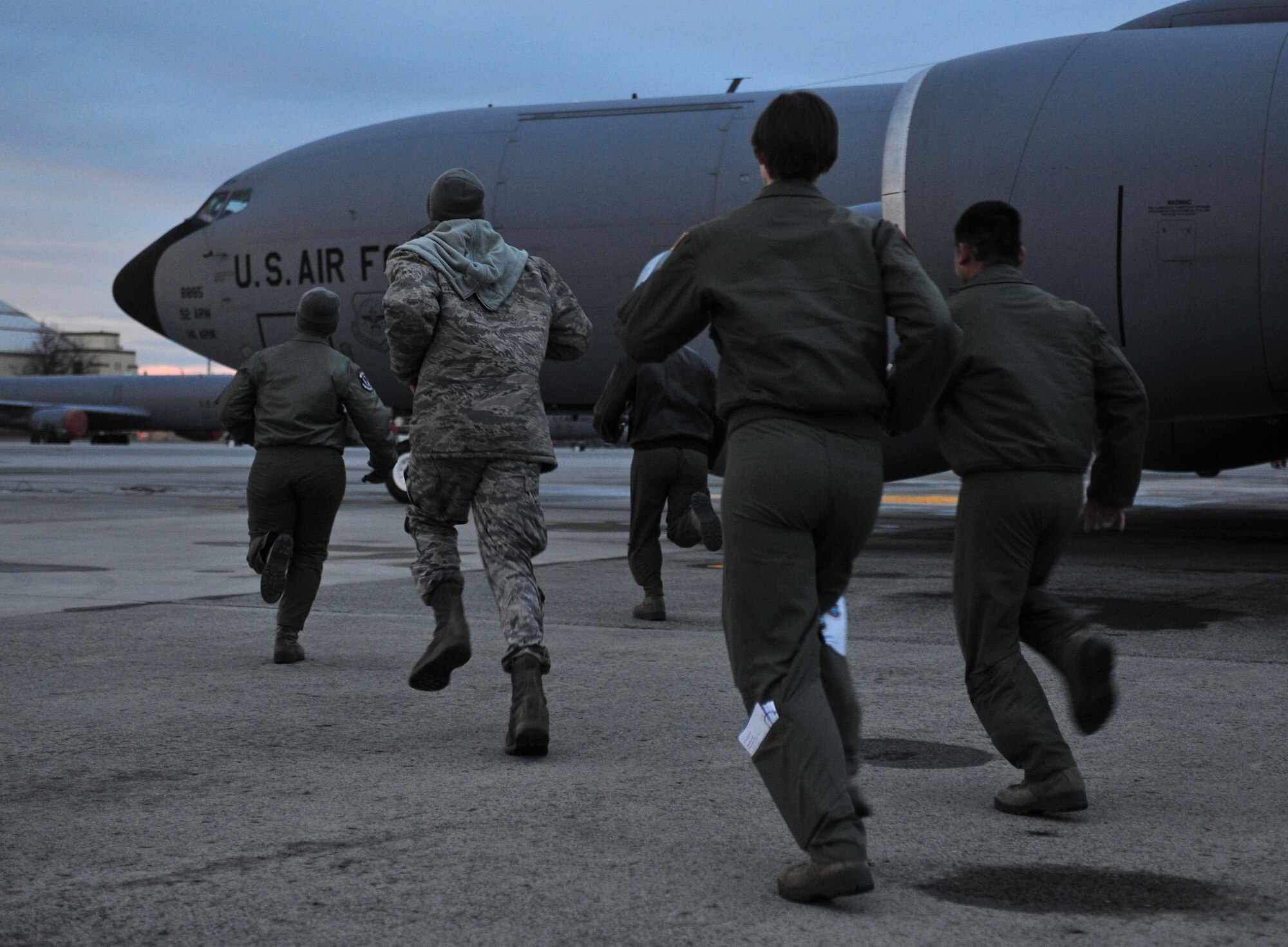 Members of the 93rd Air Refueling Wing run to a KC-135 Stratotanker during a training scenario on the flightline at Fairchild Air Force Base, Wash., Dec. 17, 2013. The training is to prepare KC-135 crews on short notice response situations. (U.S. Air Force photo by Airman 1st Class Ryan Zeski/Released)