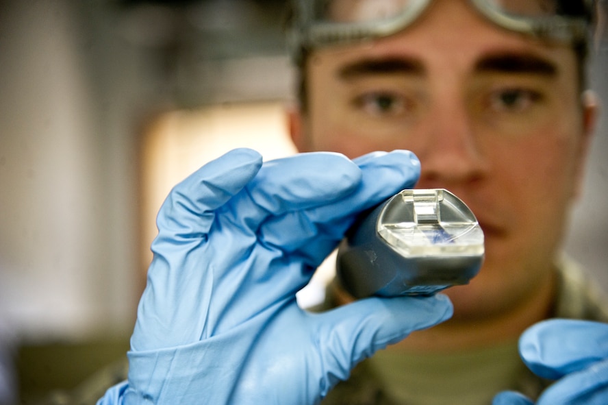 Senior Airman Cole Peck, 5th Logistics Readiness Squadron fuels laboratory technician, looks through a refractometer which is used to determine the amount of icing inhibitor present in fuel, at Minot Air Force Base, N.D., Dec. 10, 2013. At the base level quality assurance and testing includes the receiving, storing and monitoring of jet fuel, liquid oxygen, and all ground fuels used at Minot AFB. (U.S. Air force photo/Senior Airman Brittany Y. Auld)